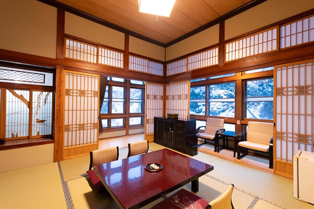 藤三旅館の和室。窓から渓流を望む、心安らぐ大正ロマンの客室