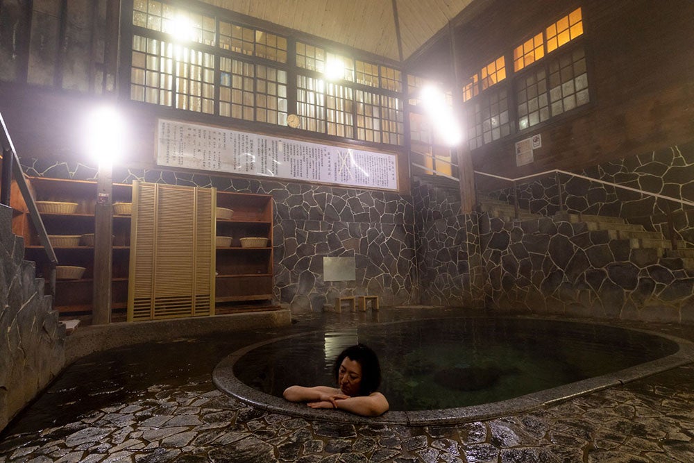 立ち居浴専用、日本一深い自噴天然岩風呂「白猿の湯」。藤三旅館の名物温泉