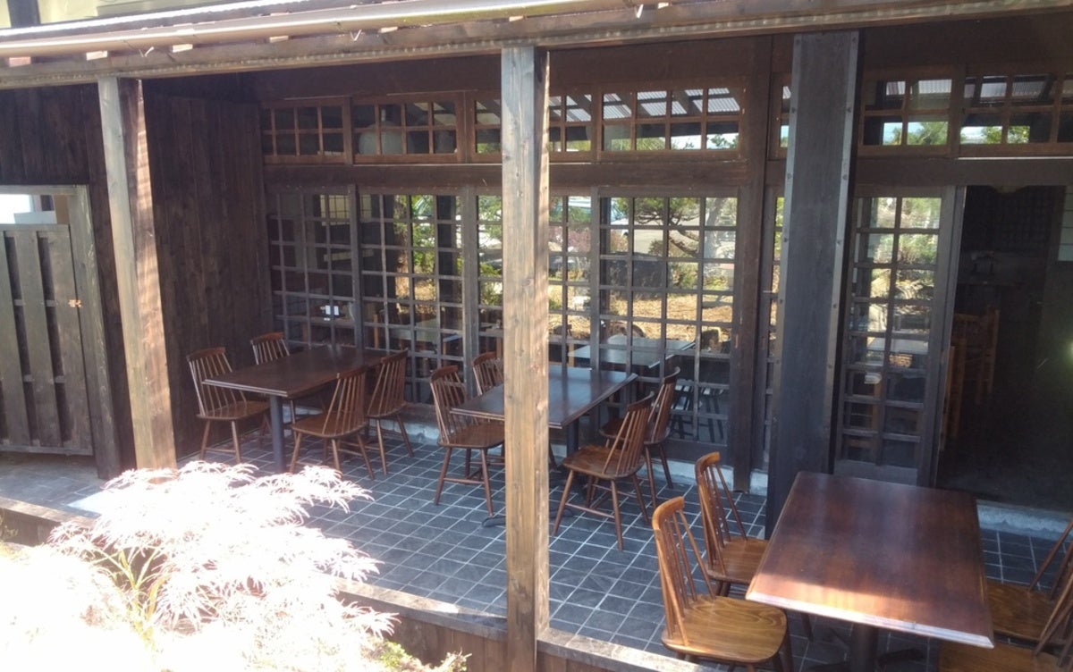 和食処のテラス席にセッティングされた木製のテーブルとチェア