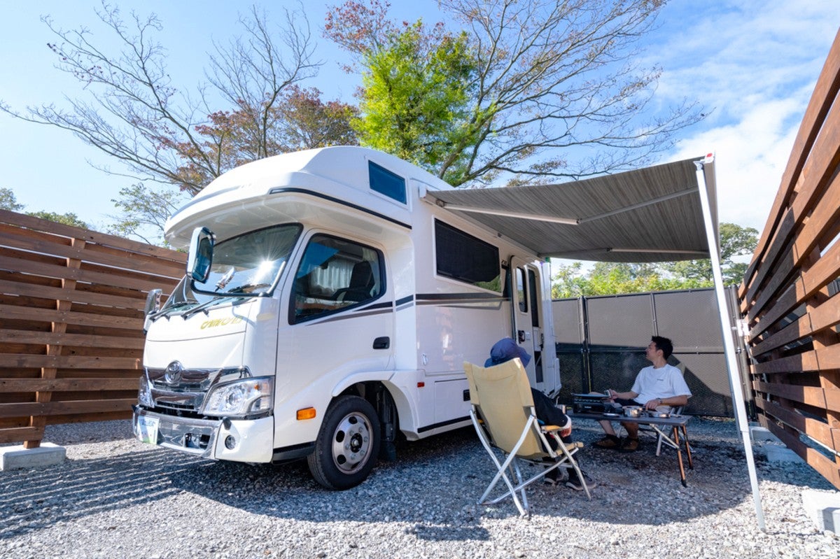 キャンピングカーのサイドオーニング下でくつろぐ男性