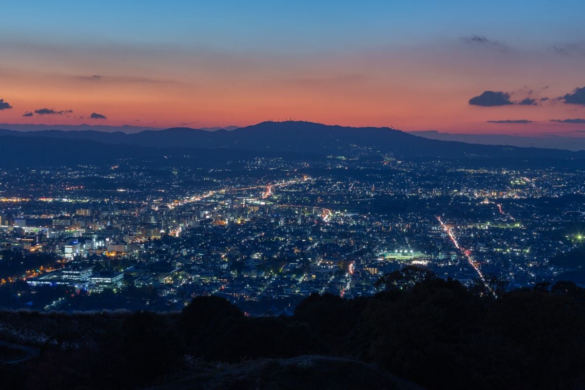 夕焼け色の空と奈良市街の夜景を一望する高台の眺望。