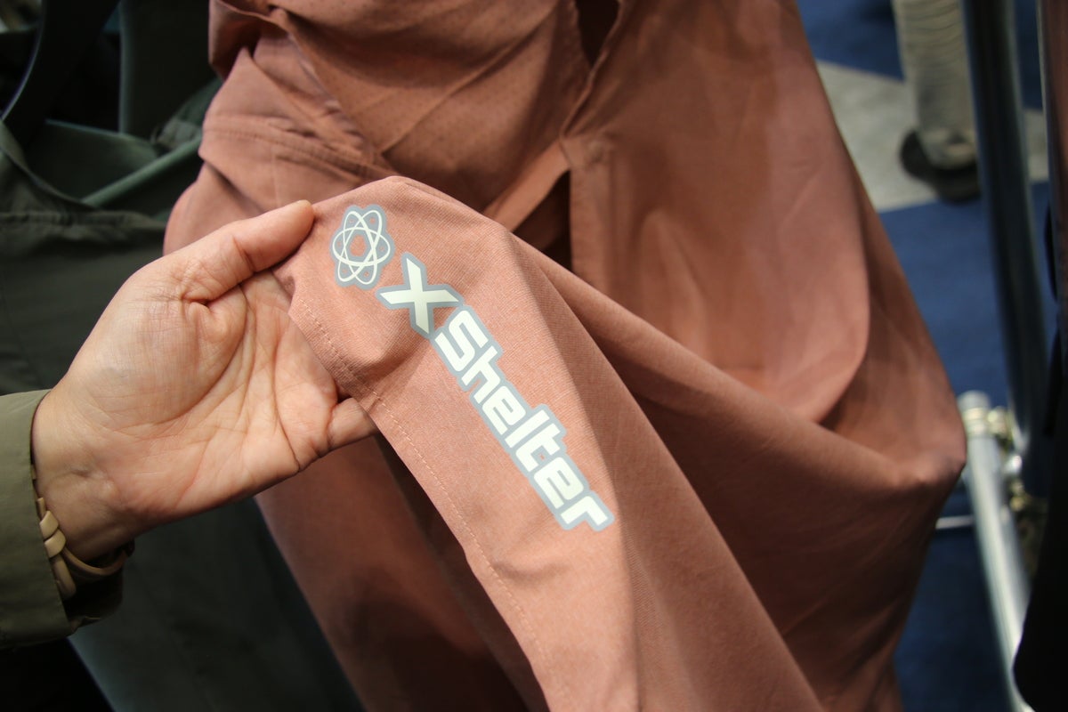 ポンチョのロゴプリントを部分を手に取っている写真