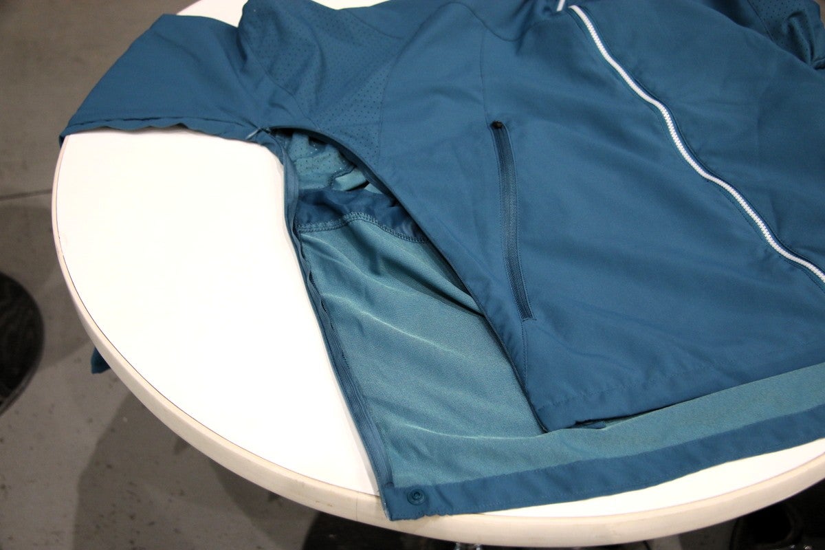 テーブルの上に脇のファスナーが開いたアウターウエアを置いた写真