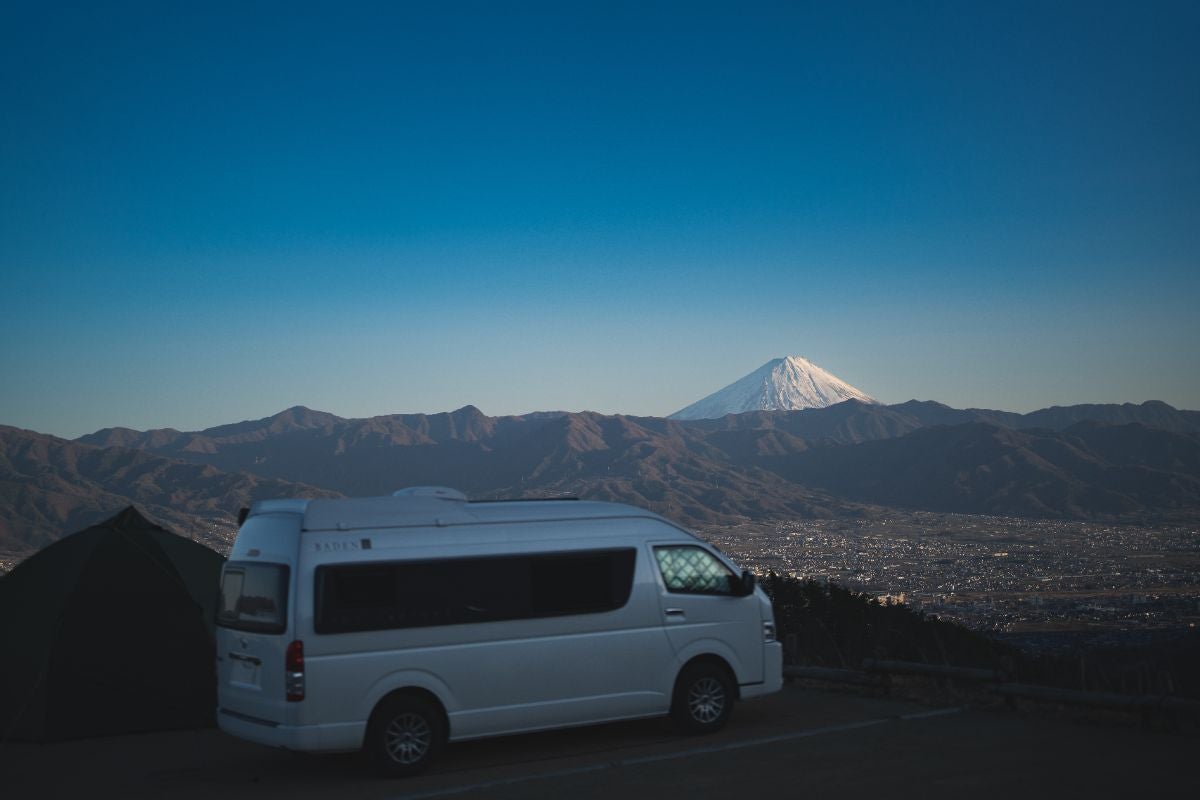 駐車場に止めたハイエースと山向こうに見える富士山