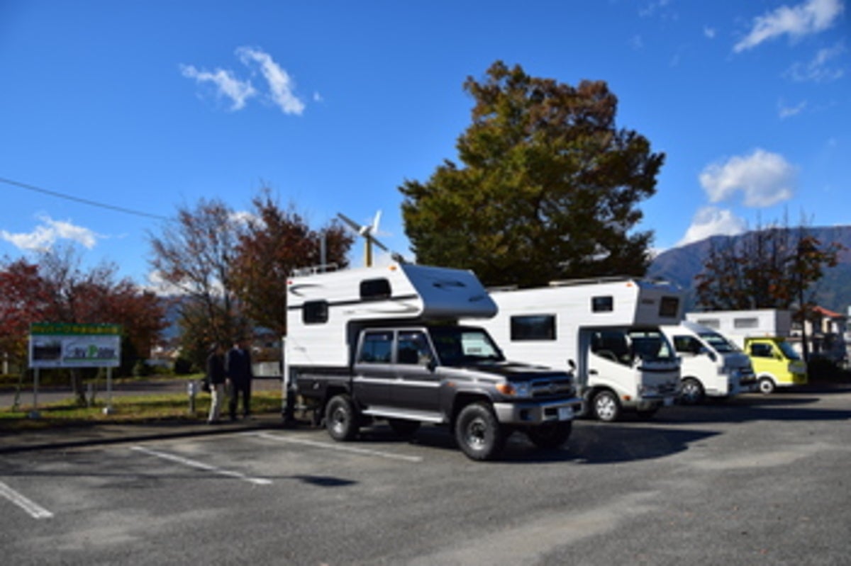 RVパークのサイトにキャンピングカー数台が駐車している風景