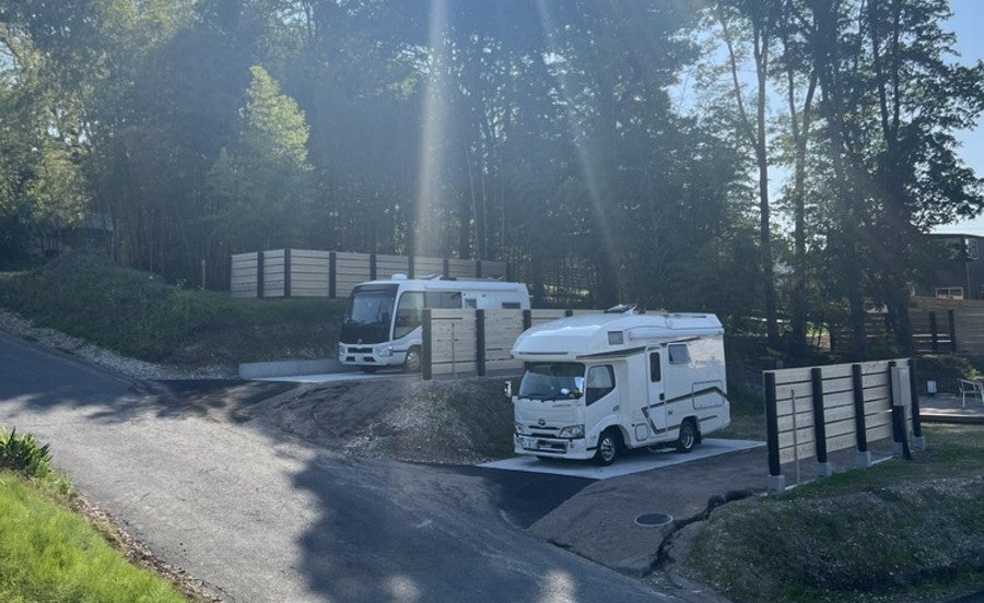 段違いのRVパークサイトに駐車しているキャンピングカー2台