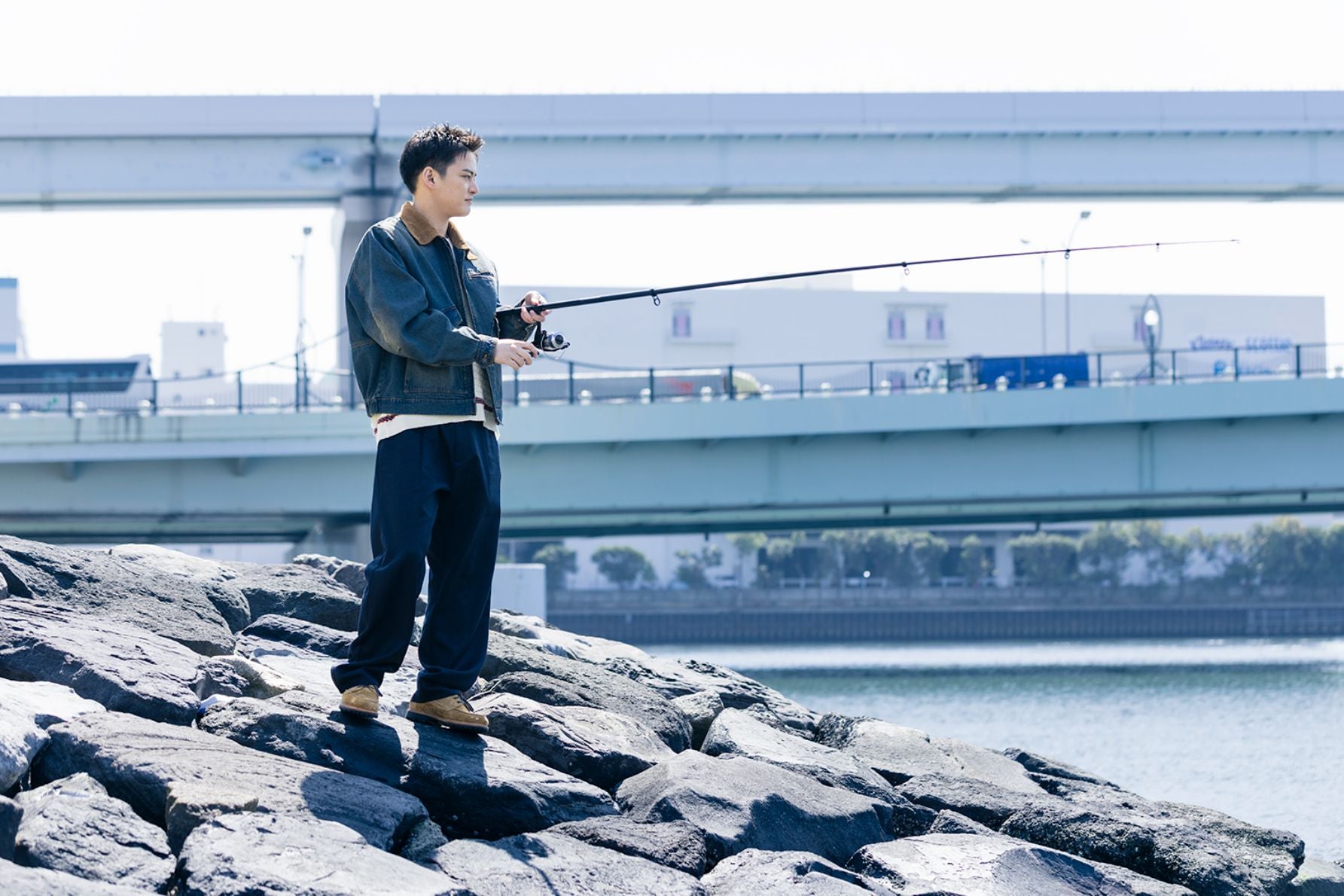 青空の下、東京湾の堤防で竿を構える俳優・中山優馬のフィッシングシーン
