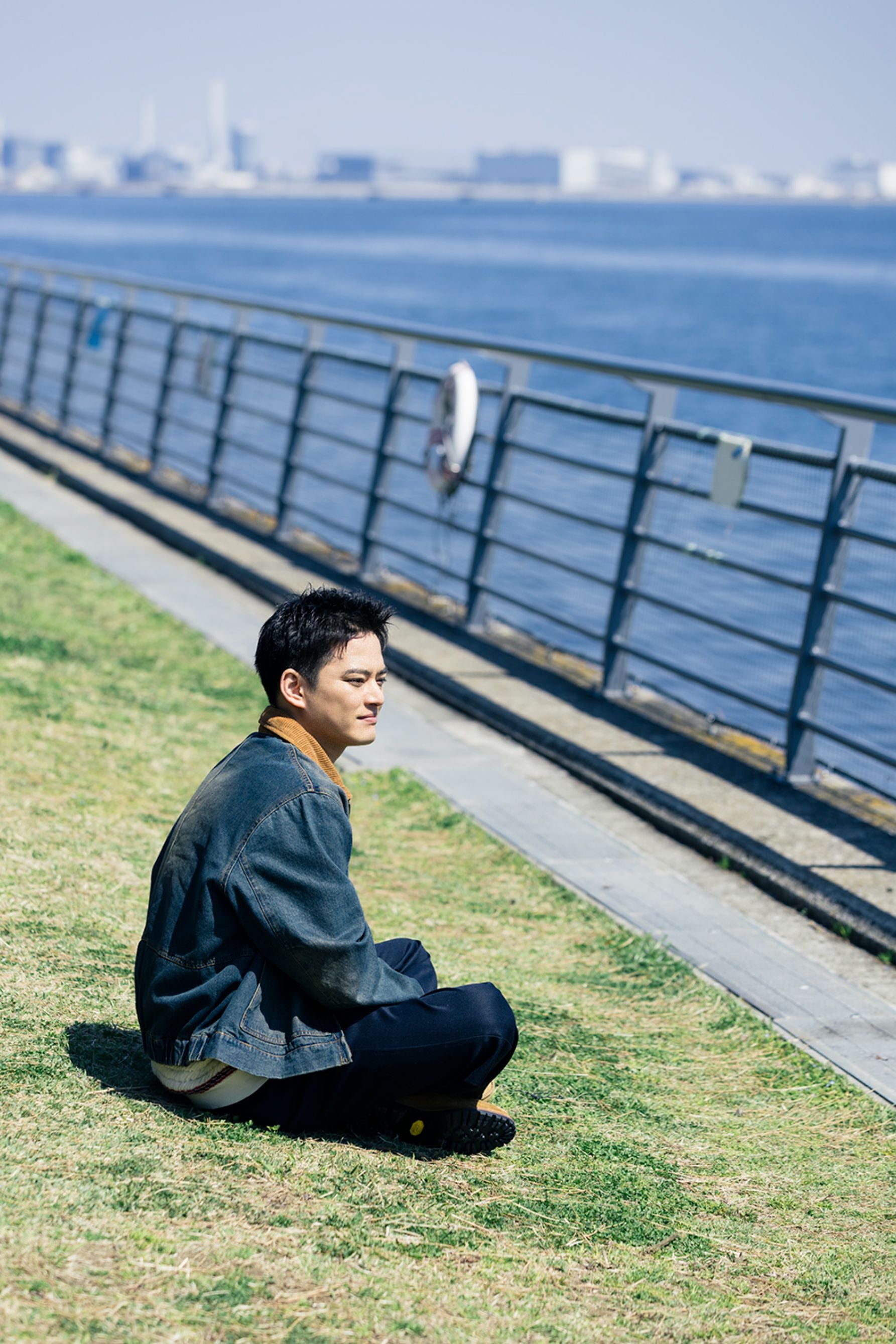 東京湾の波穏やかな水面と対峙する、中山優馬の後ろ姿を捉えたポートレート