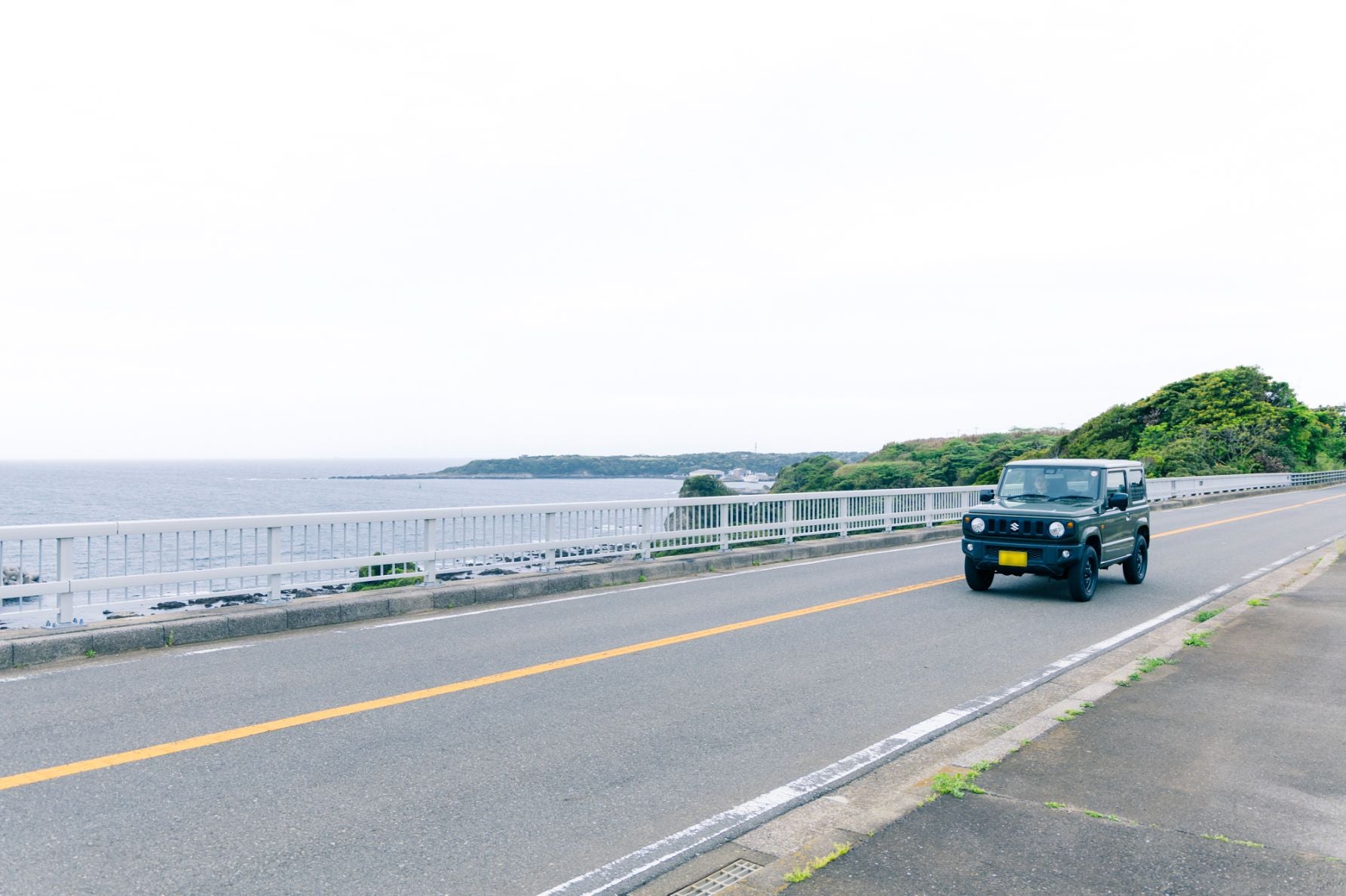 毘沙門湾沿いの県道215号を走行するクルマ