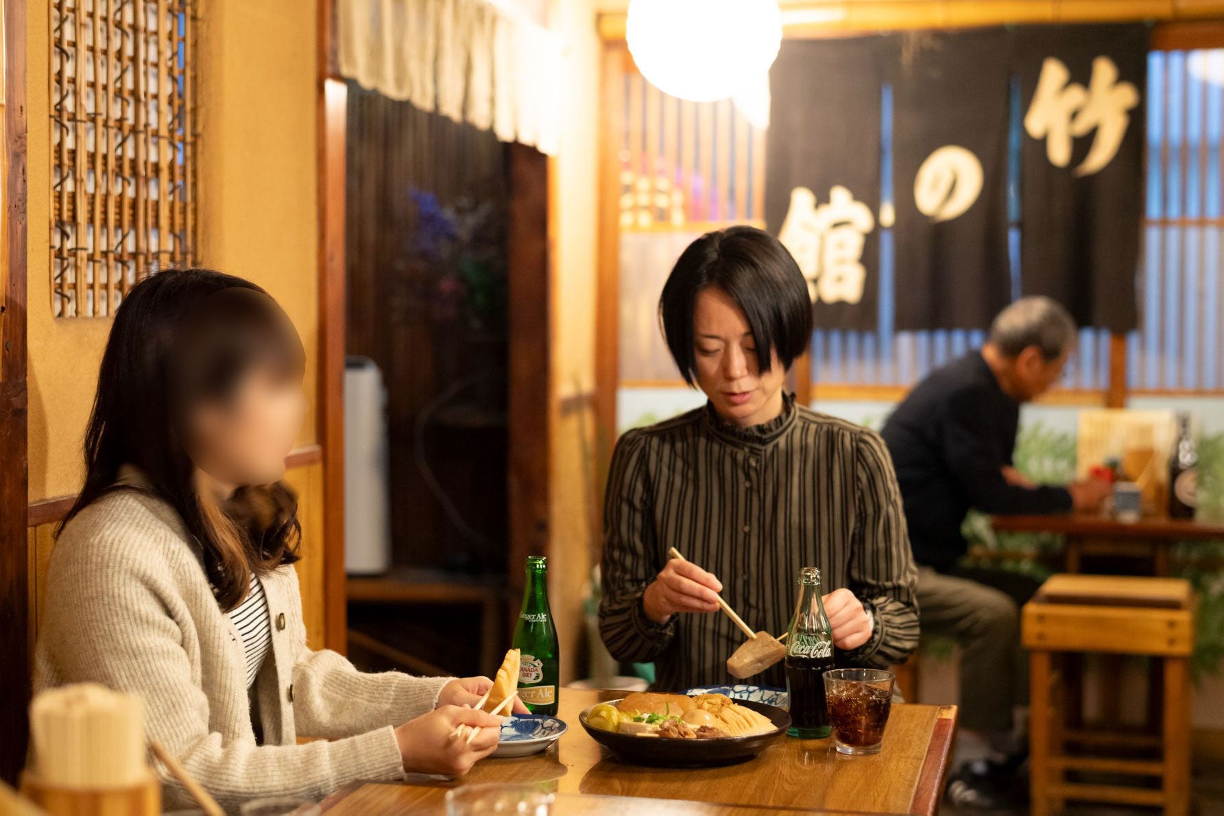 雰囲気のよい店内でおでんをつまみながら話に花を咲かせる2人。地元の常連さんも多いという