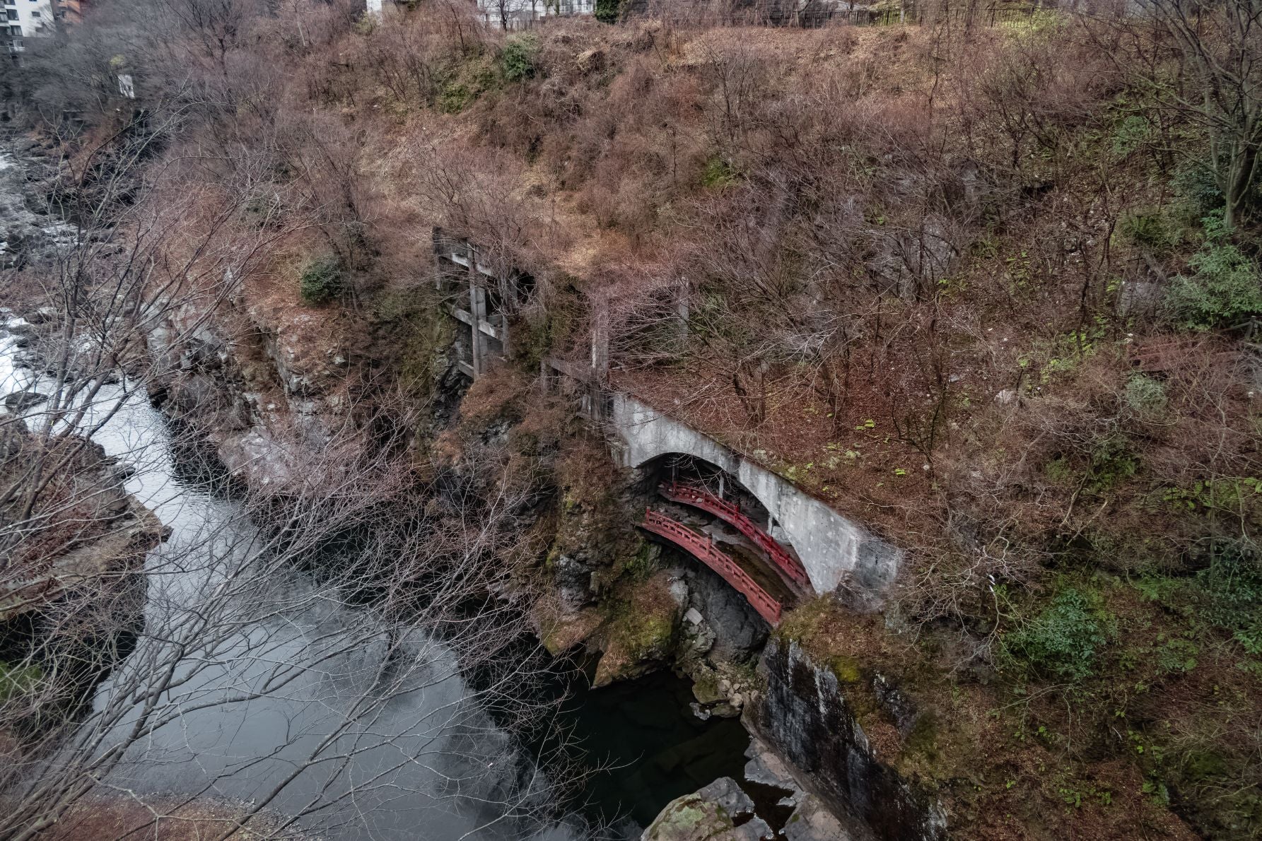 鬼怒川沿いに旅館が建ち並ぶ一角に見える赤い欄干の廃橋