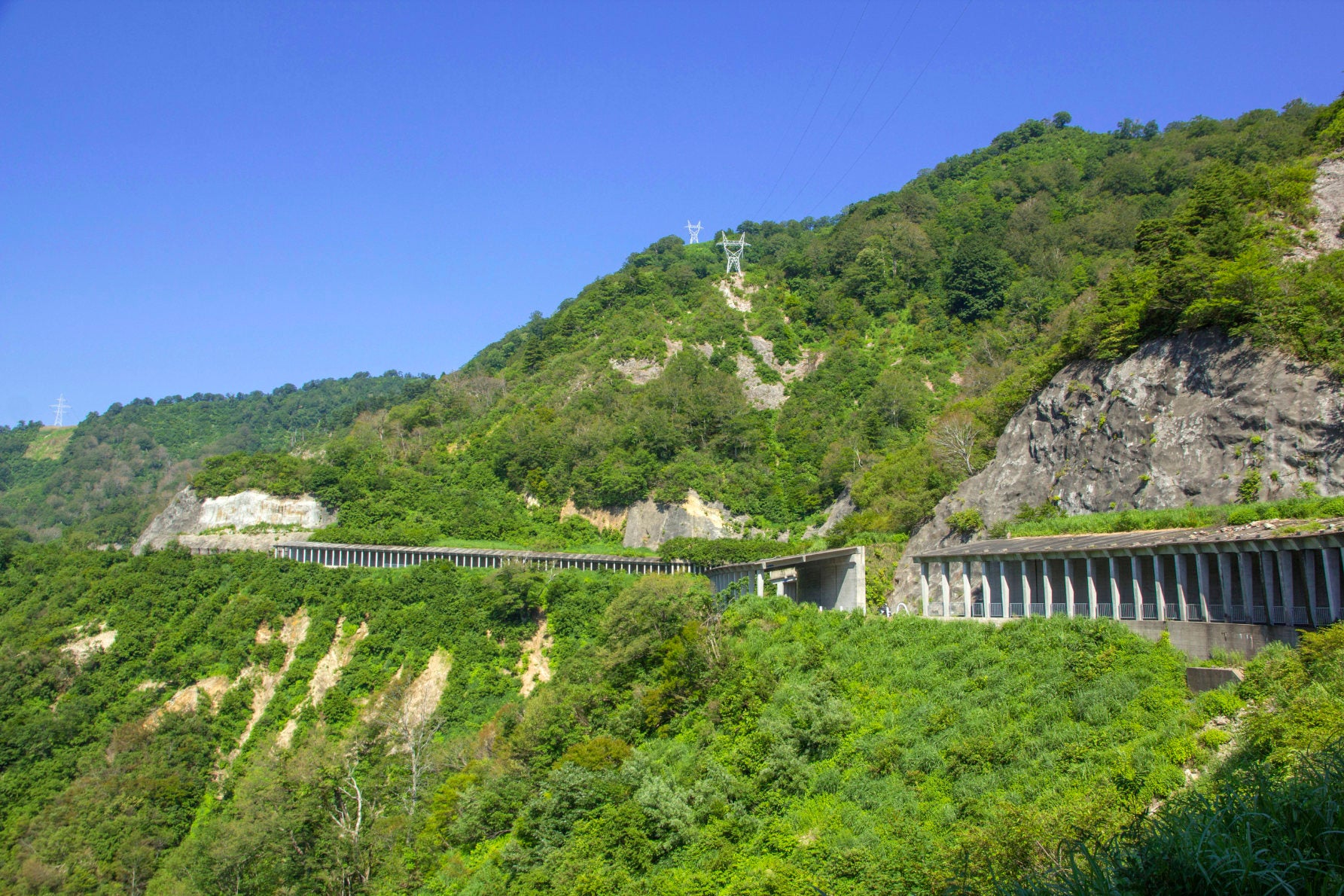 ALT 厳しい自然環境を物語る、国道252号名物の連続するスノーシェッド。山肌にへばりつくようにして作られた道沿いからは、日本の土木技術の凄さと大自然の険しさを同時に感じる