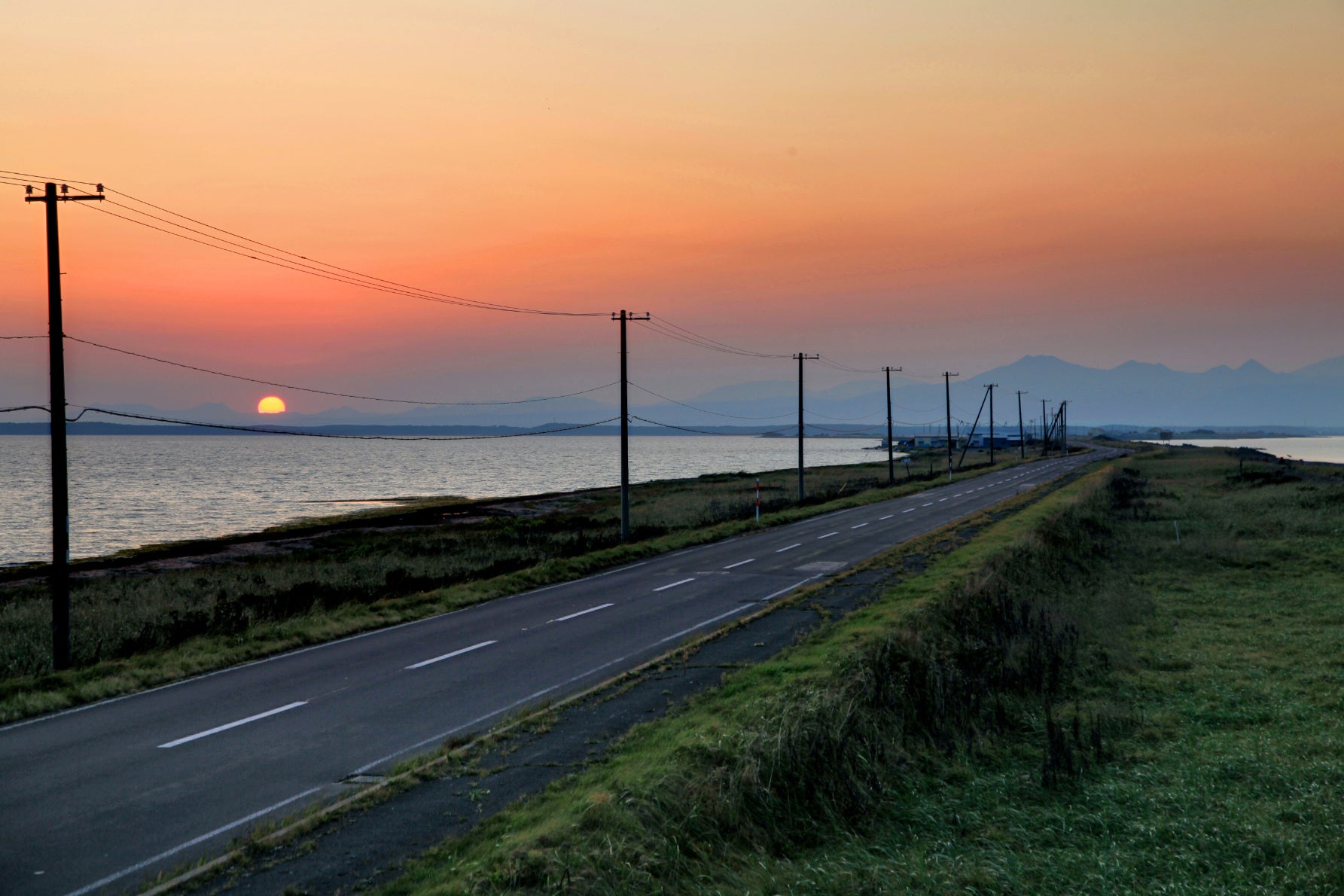 ALT 知床連山のシルエットを背景に、静かに一日が暮れていく野付半島のノスタルジックな夕焼けが映える