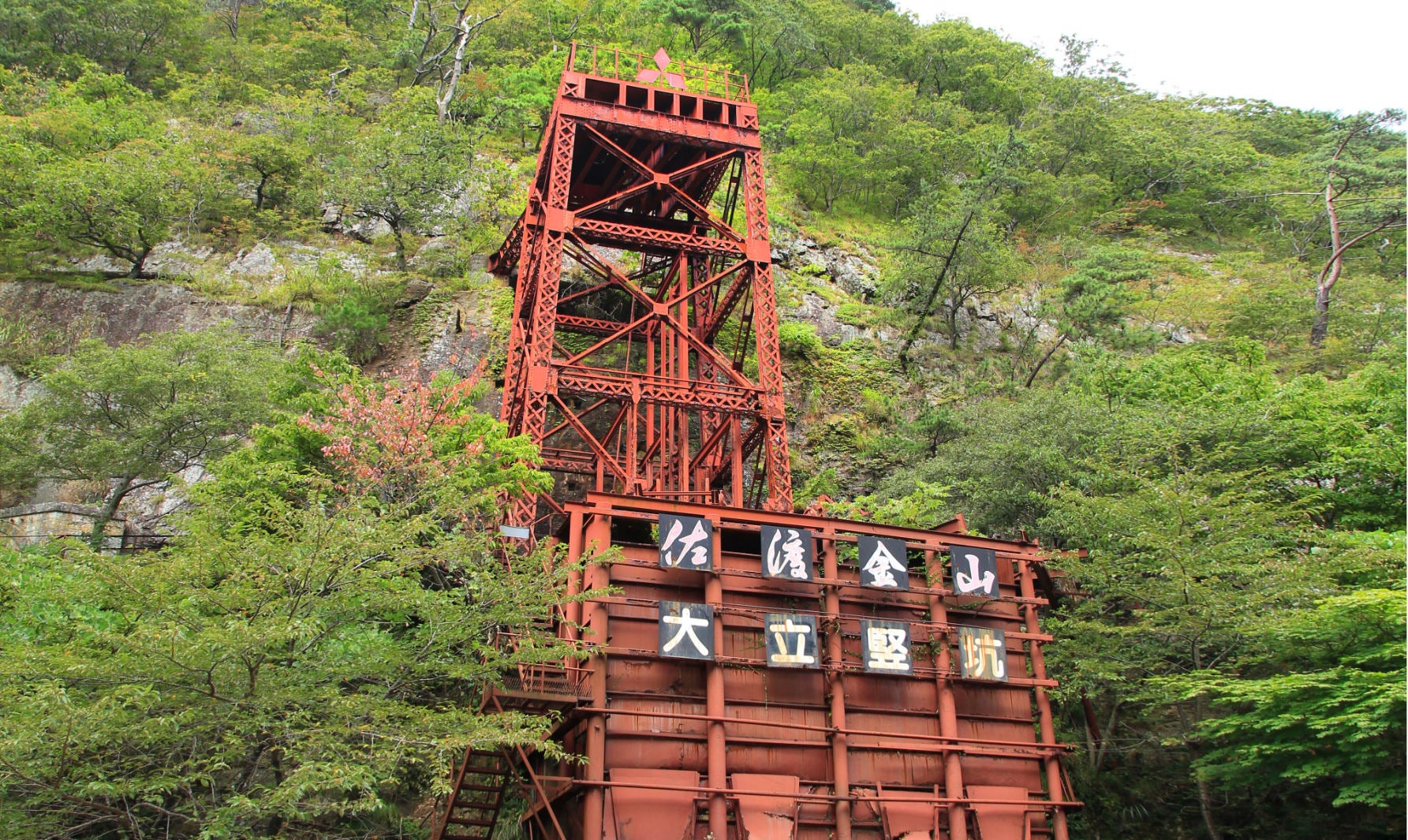 ALT 佐渡金山の歴史を今に伝える「大立竪坑（おおだてたてこう）」の赤茶けた鉄塔。エレベーターによる垂直の運搬坑道。大佐渡スカイラインのルート沿い近くに位置し、近代化産業遺産として圧倒的な存在感を放っている