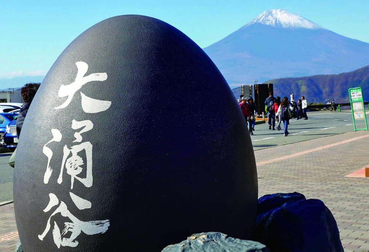 大涌谷名物の黒たまごのモニュメントの後にも雄大な富士山が見える