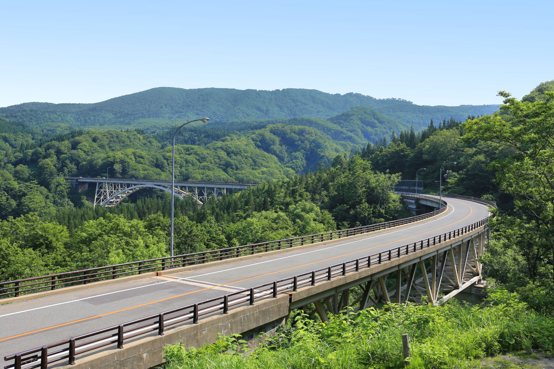 山形自動車道・月山ICを過ぎ、山岳ルートへ。道幅の広い快適な道路がブナの原生林の中を貫き、標高を上げるにつれ深山の趣が深まっていく