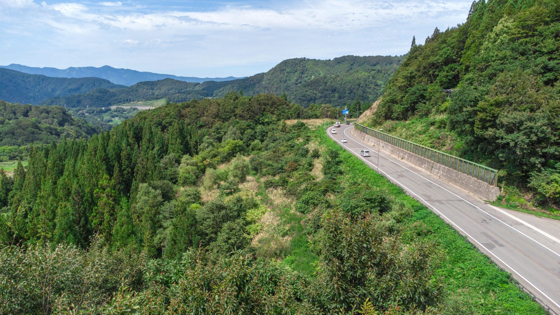 トンネルを抜けると視界が広がり、急峻な山肌に張り付くような集落が見える。かつて湯殿山参詣の宿場町として栄えた歴史ある山村だ
