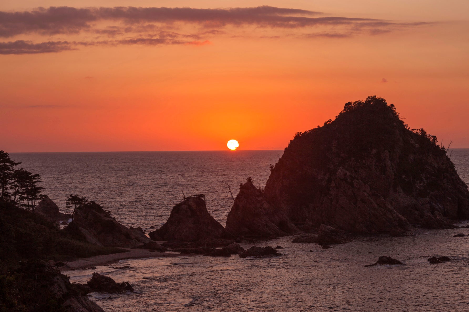 海に浮かぶ菜種五島をシルエットに、日本海へと沈む美しい夕日。時間がたつのを忘れて見とれてしまう絶景スポットだ