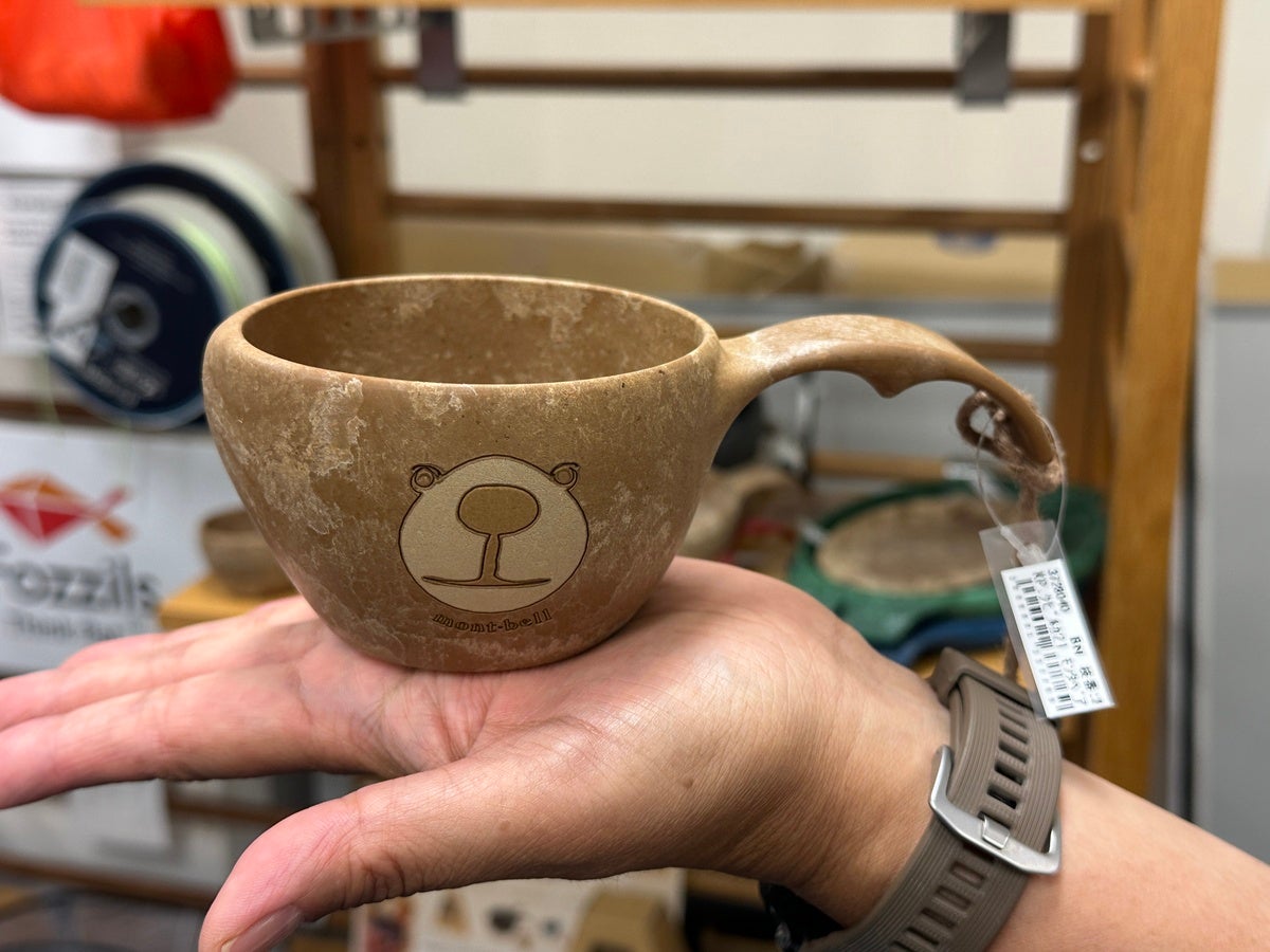 モンベル 手のひらに載せたロゴ入りの木目調カップ（木製ククサ風マグ）
