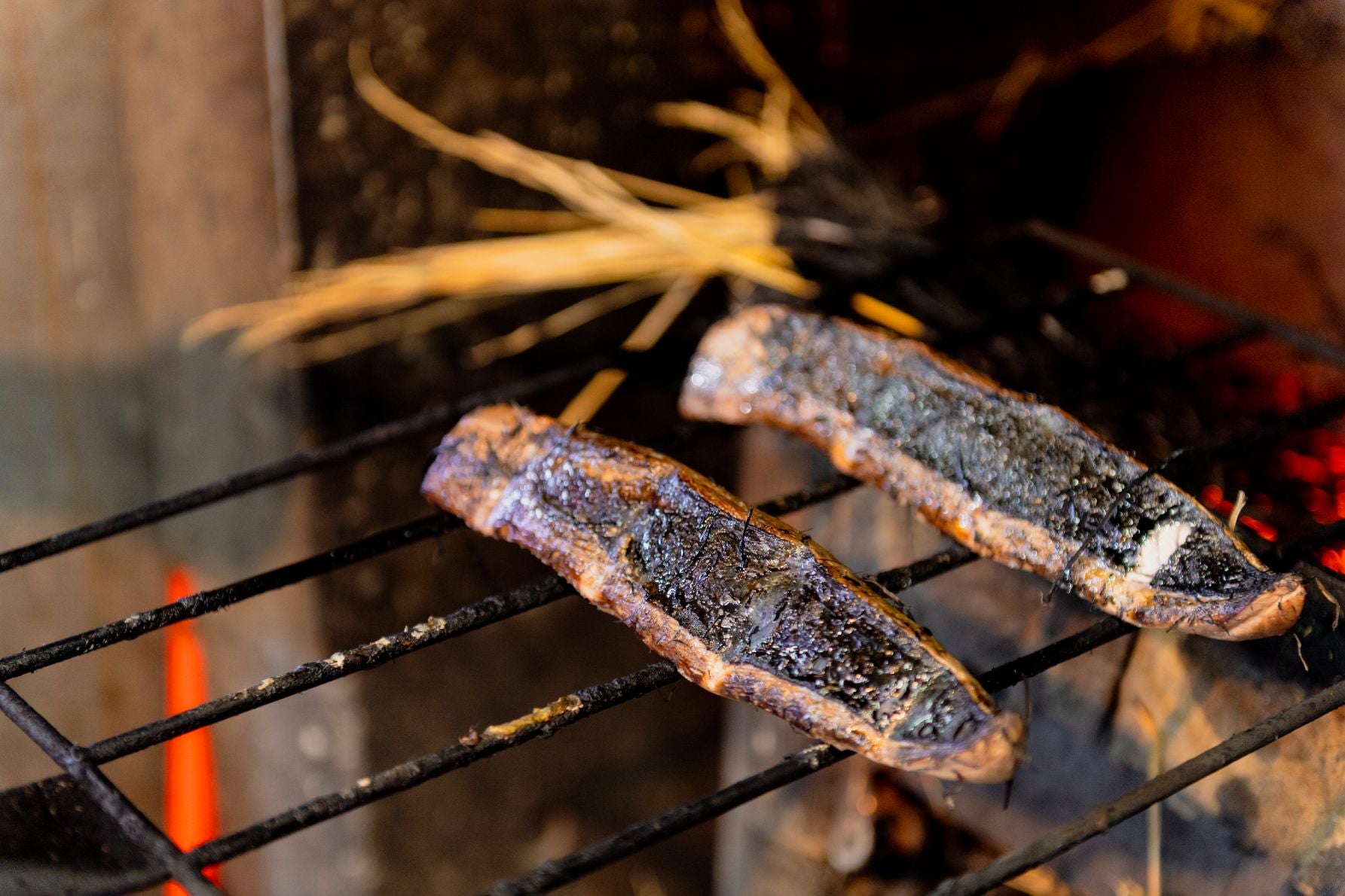 カツオのさくを自らの手で藁焼きの窯に入れ、タタキ作りができる