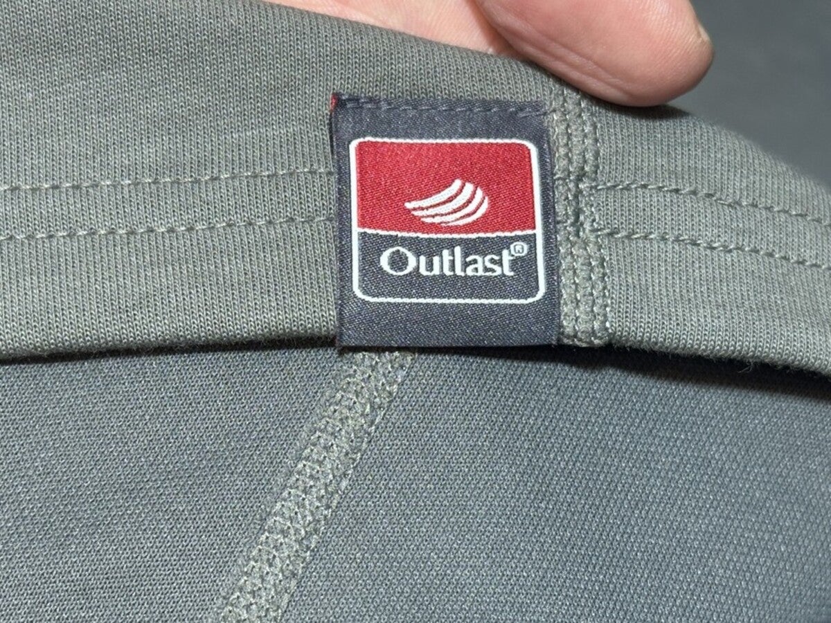 赤色のOutlast（アウトラスト）ブランドタグが縫い付けられた生地のアップ
