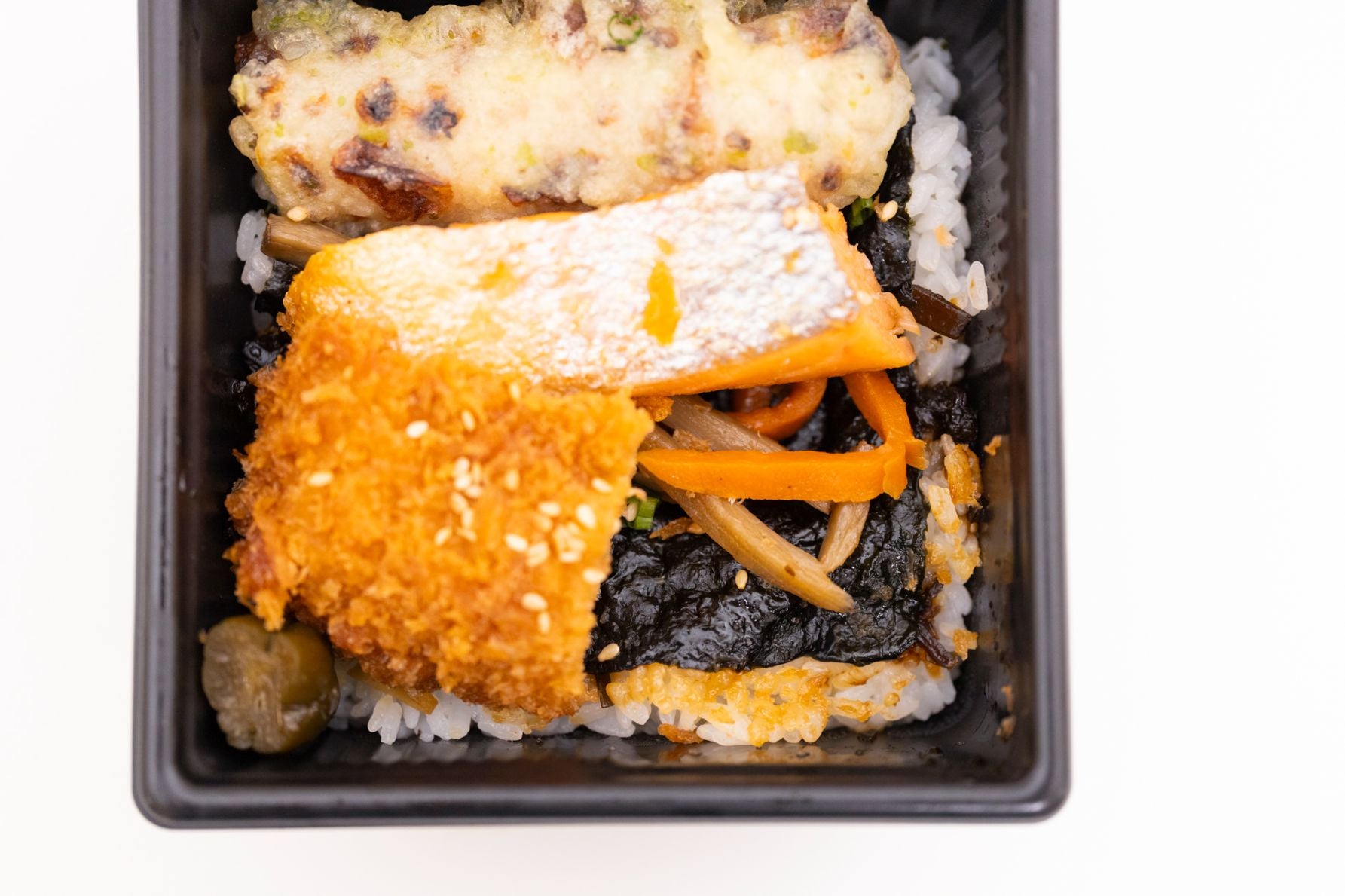お弁当上から、ちくわの磯辺揚げ、焼き鮭、イカフライが並び、おかずの下にはきんぴらごぼう、キュウリの漬物。白米の上には高級海苔の「田庄のやきのり」が敷かれている