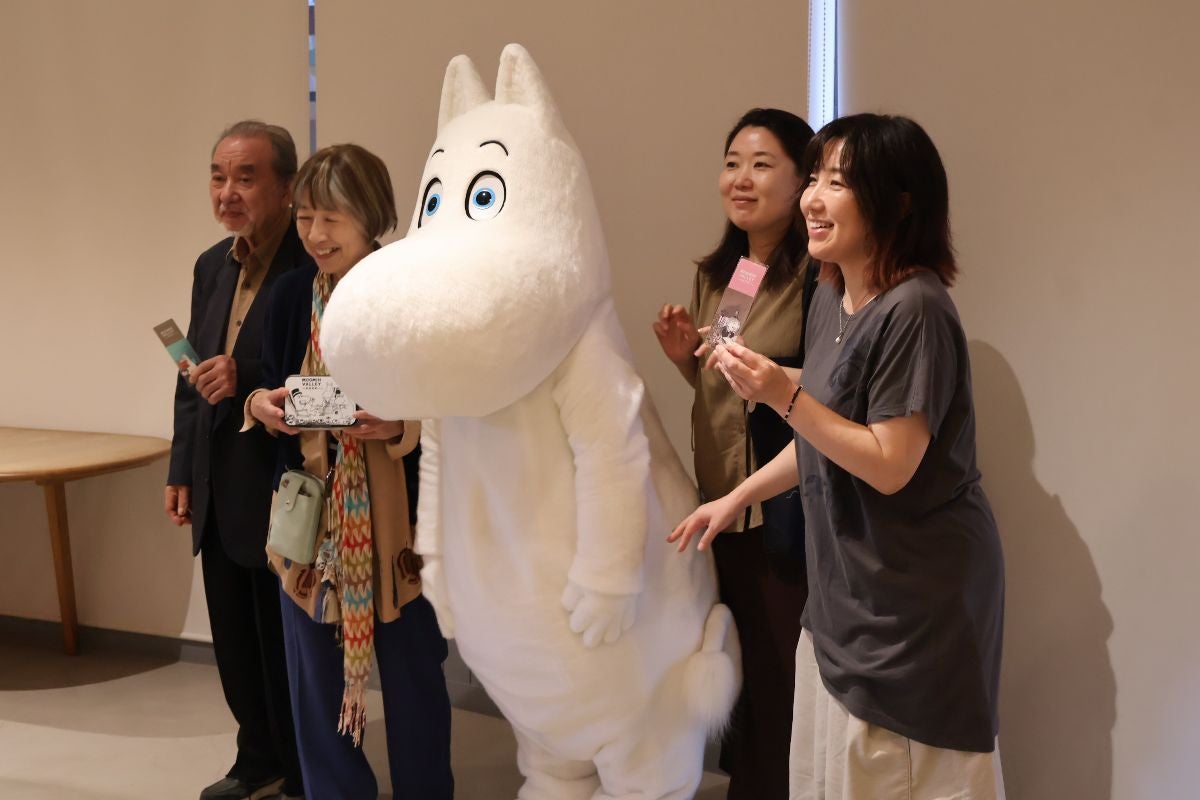 にこやかにムーミンと記念写真を撮る参加者