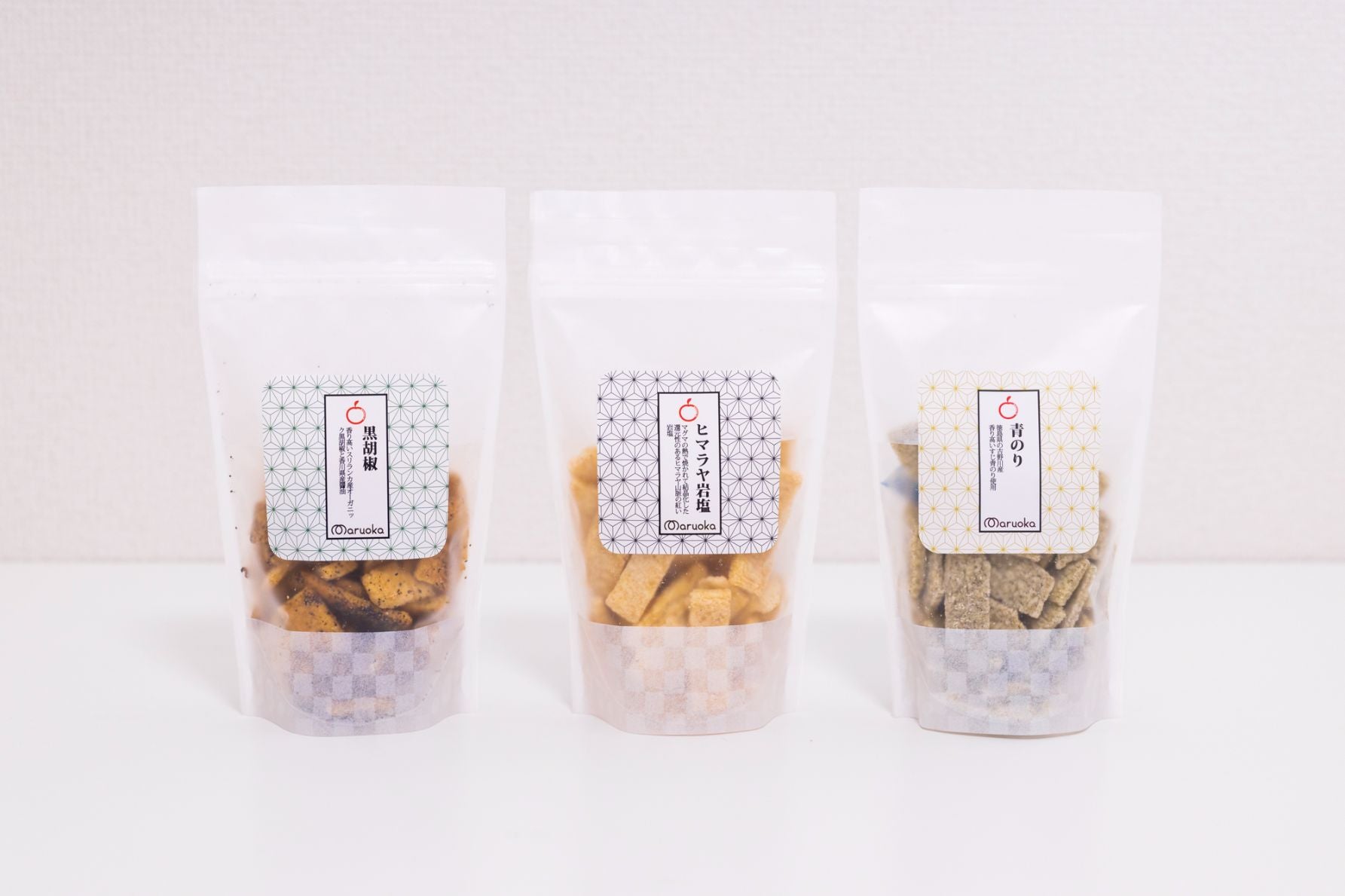 (写真左から)「まるおかオリジナル　玄米おかき」黒胡椒、ヒマラヤ岩塩、青のり、各450円