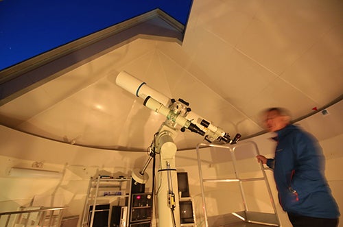 天文台で天体望遠鏡を使用する男性