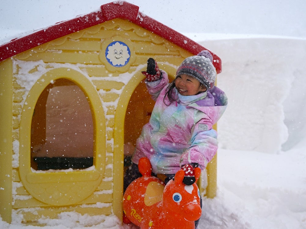 雪の中で楽しそうに遊ぶ子供