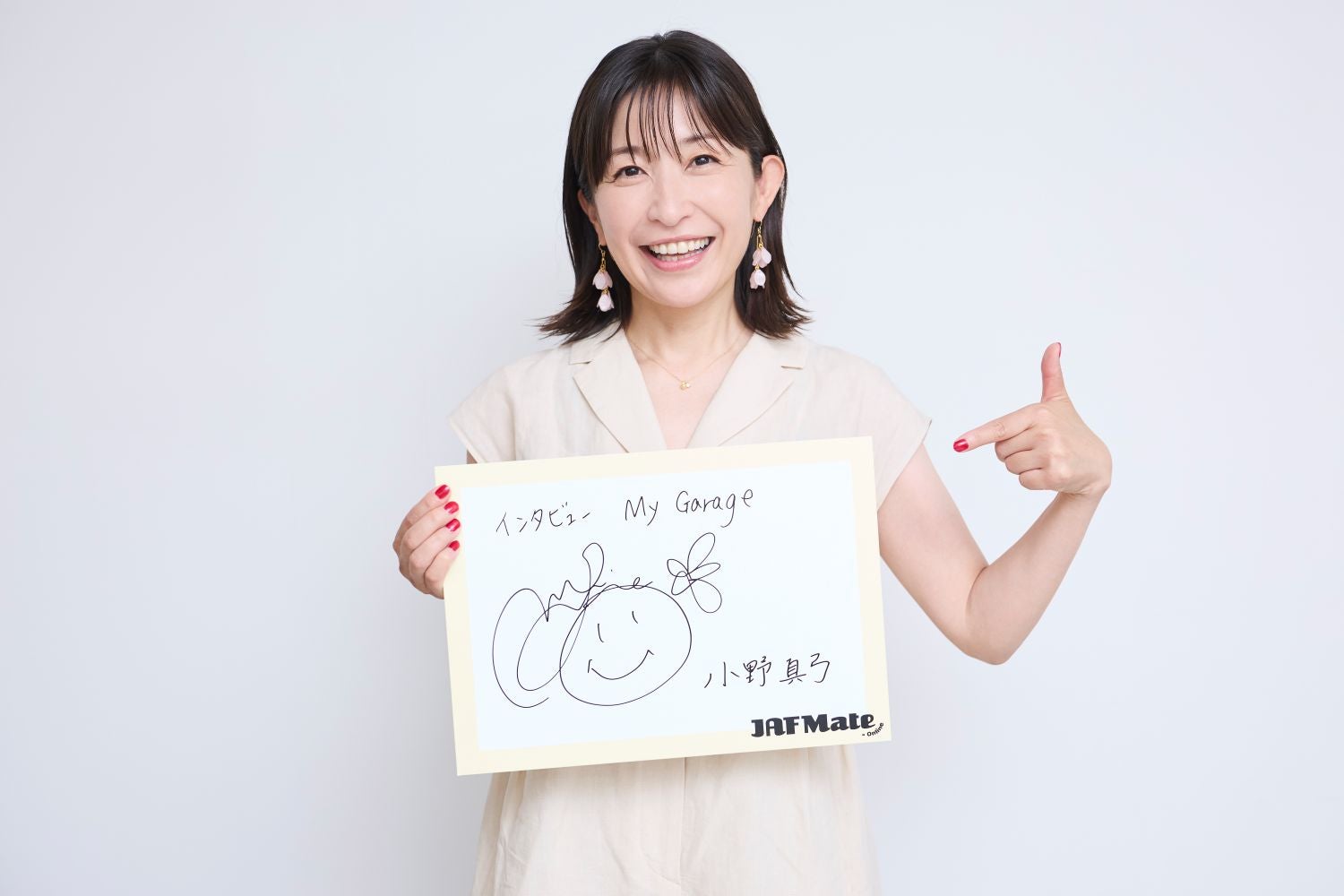 サインを持つ小野さん