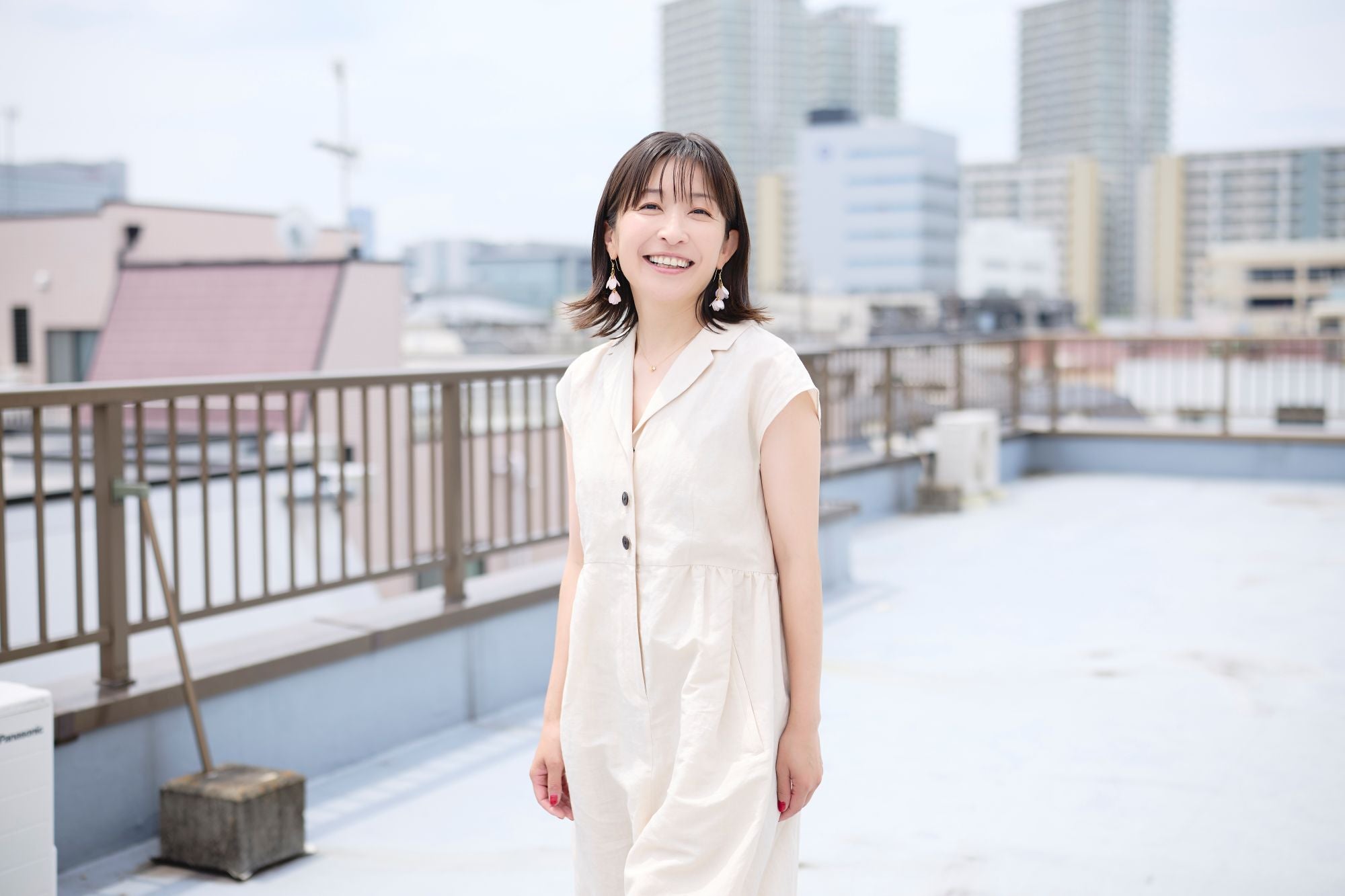 ビル屋上でほほ笑む小野さん