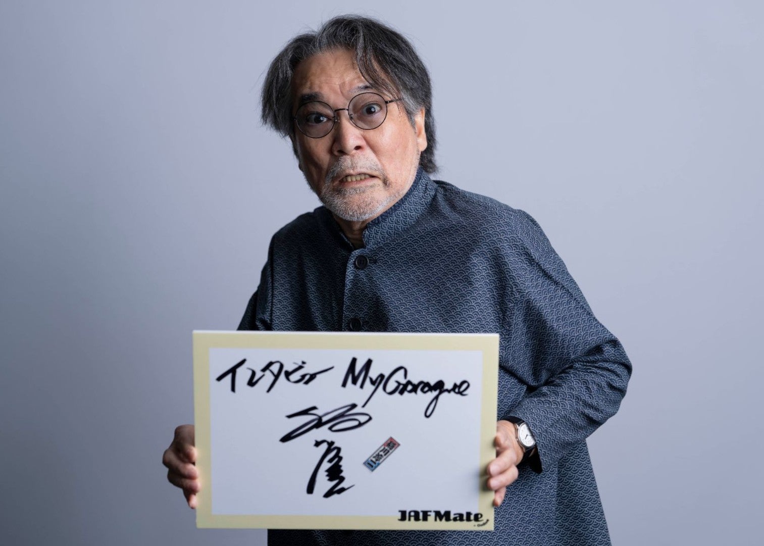 サインを持つ稲川さん