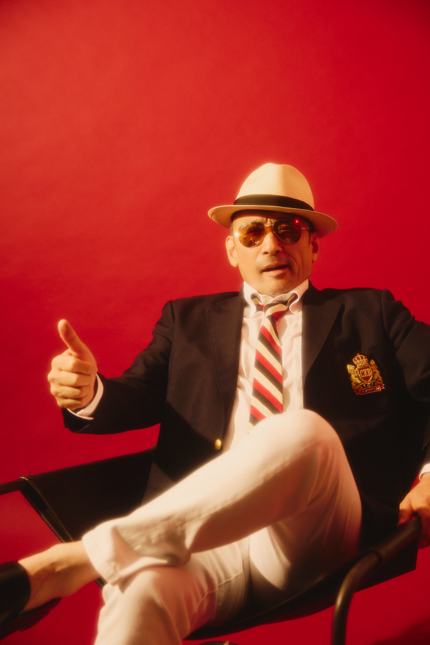 椅子に座り、ポーズをとる横山剣さん