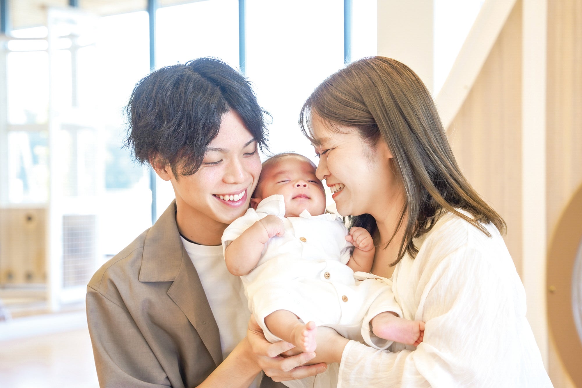 赤ちゃんを抱く夫婦の画像