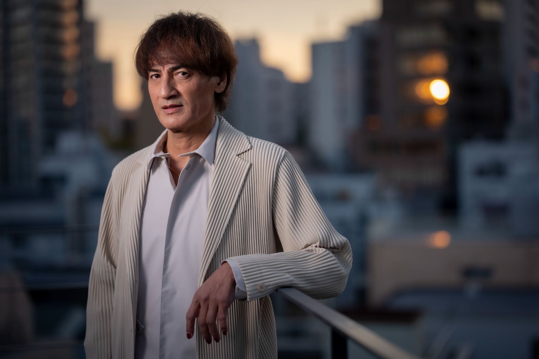 元サッカー日本代表の本並健治氏。クルマ好きとして知られ、愛車の話をする際にジェスチャーを交えているカット。