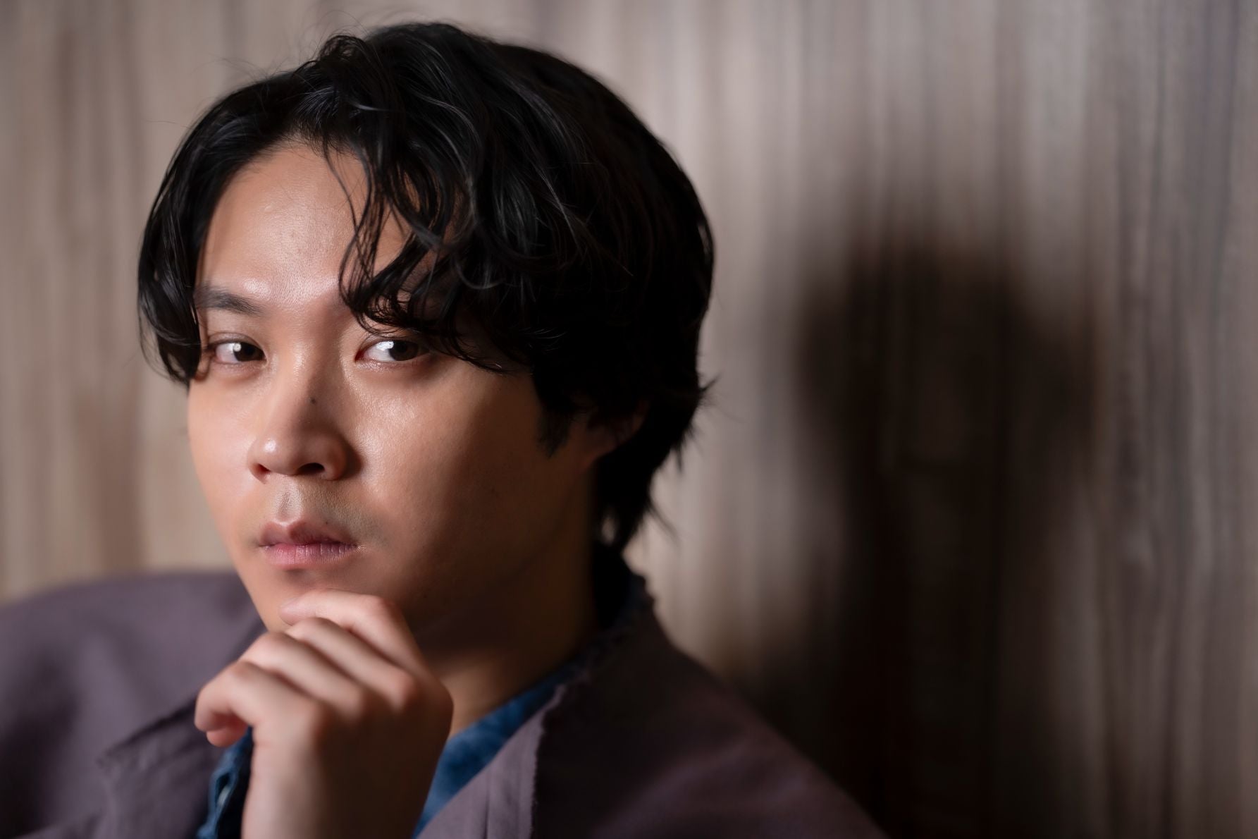 インタビュー中に顎に添えた手元が写し出された磯村勇斗氏のクローズアップ写真