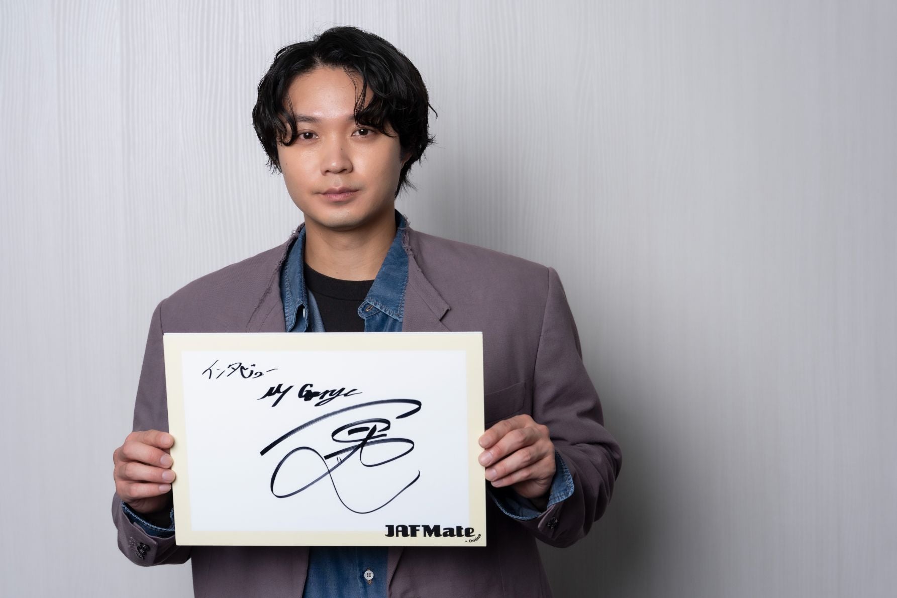 サインを持つ磯村勇斗さん