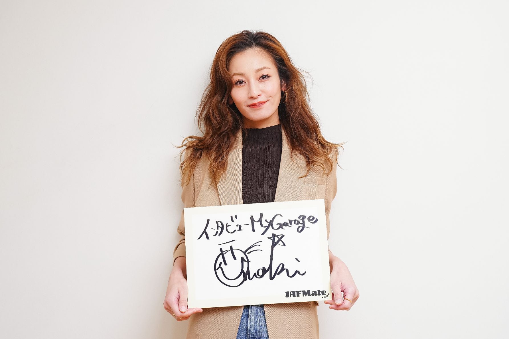 サインを持つ西山茉希さん