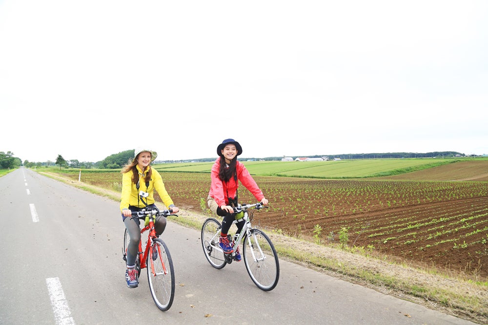 農園地帯をサイクリングする女性たち