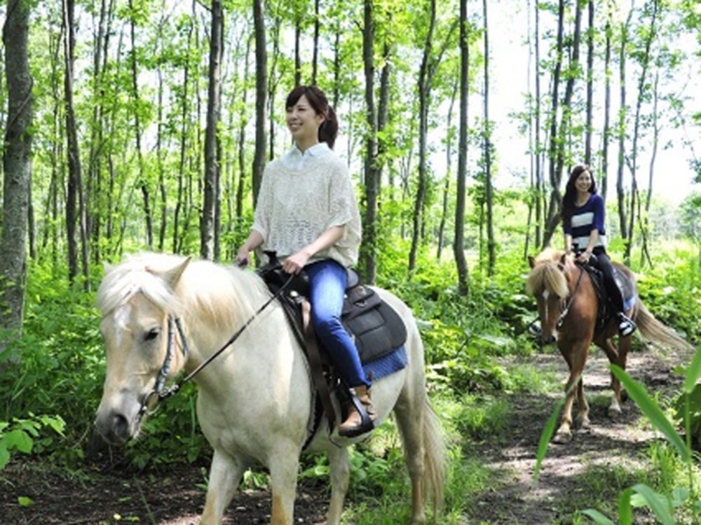 森林の中で乗馬を楽しむ女性たち
