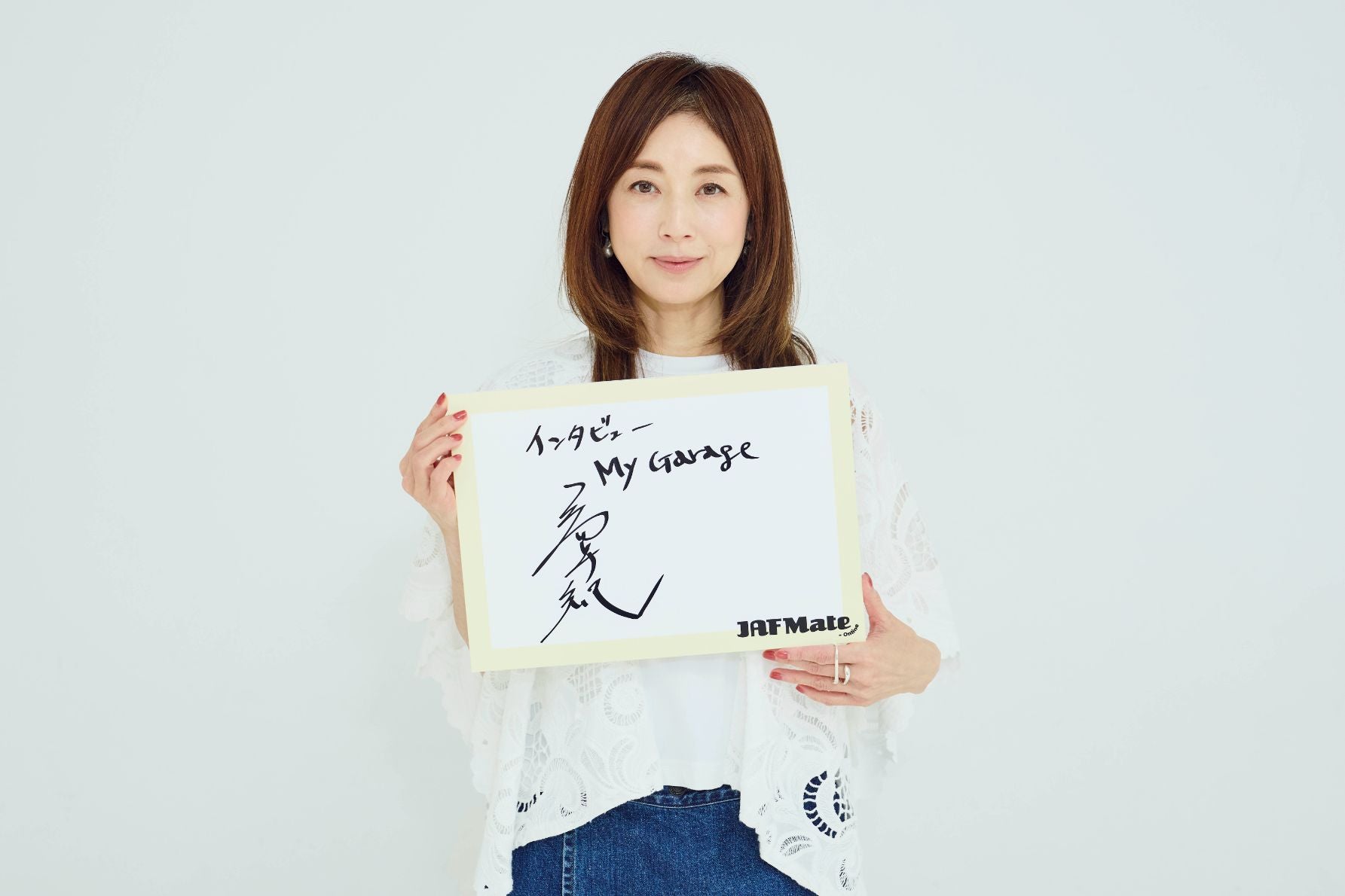 サインを持つ高岡早紀さん