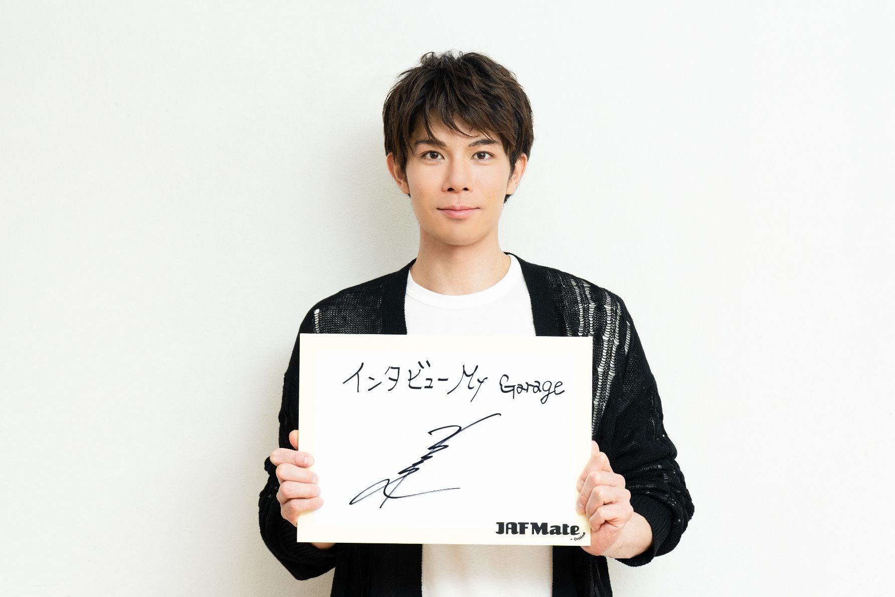 サインを持つ柿澤勇人さん
