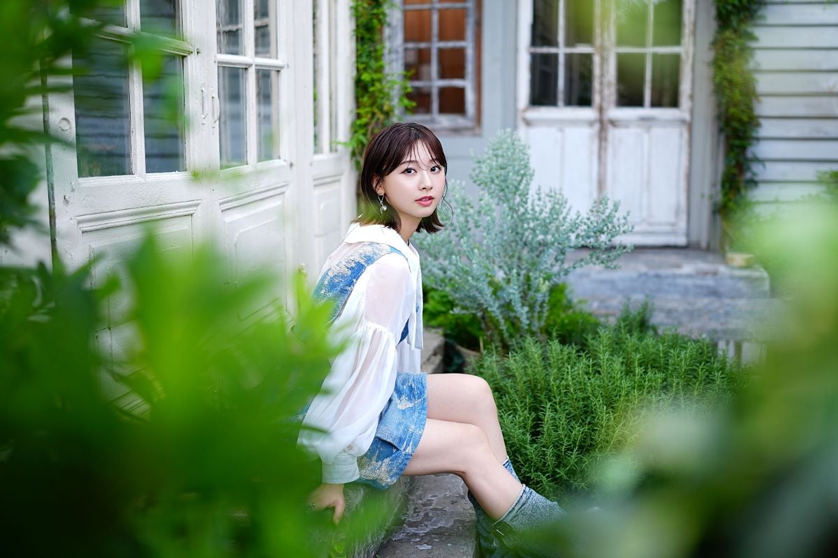 階段に腰をかけ、こちらを向く富田鈴花さん