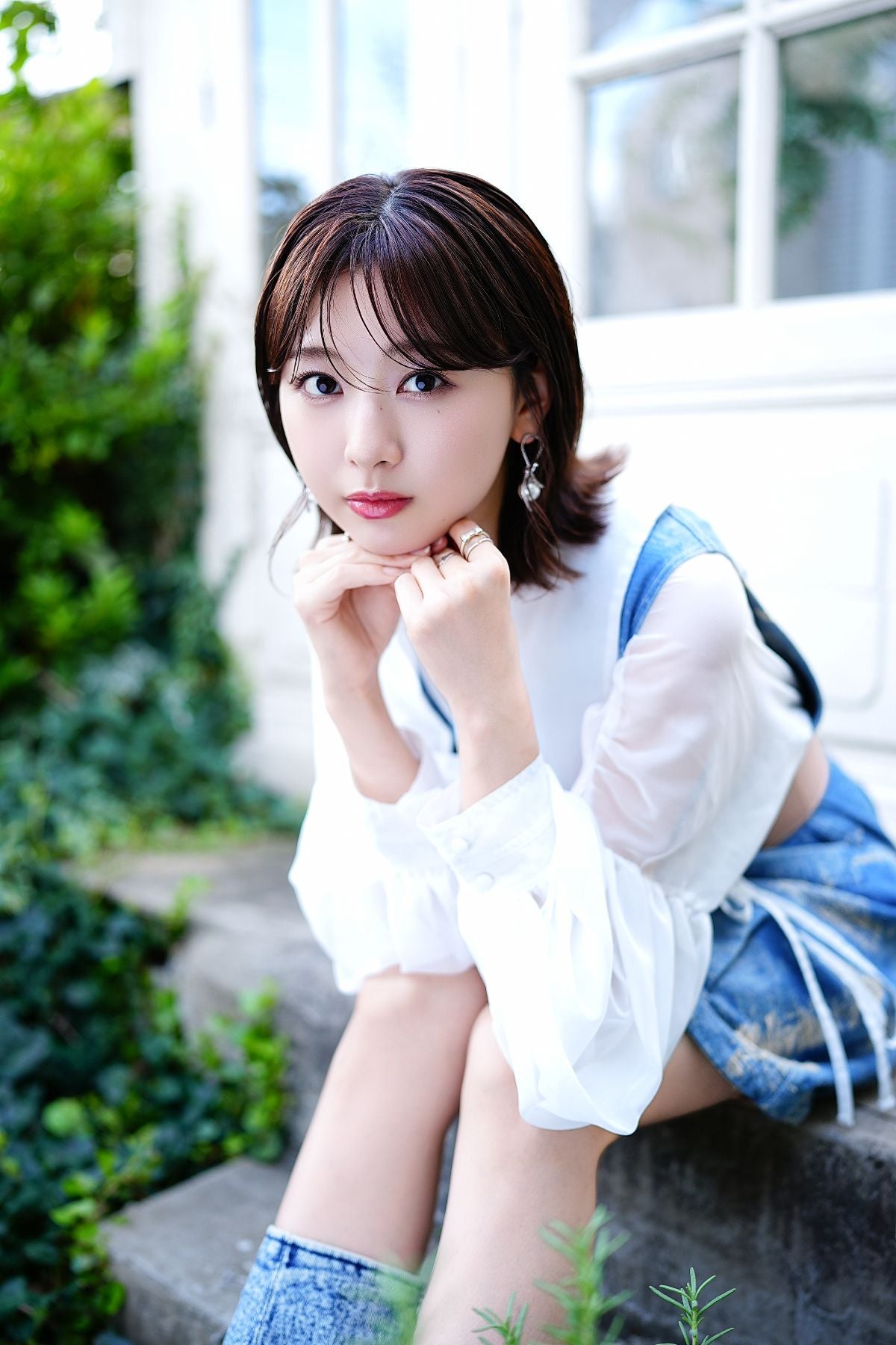 階段に腰をかけ、こちらを見つめる富田鈴花さん