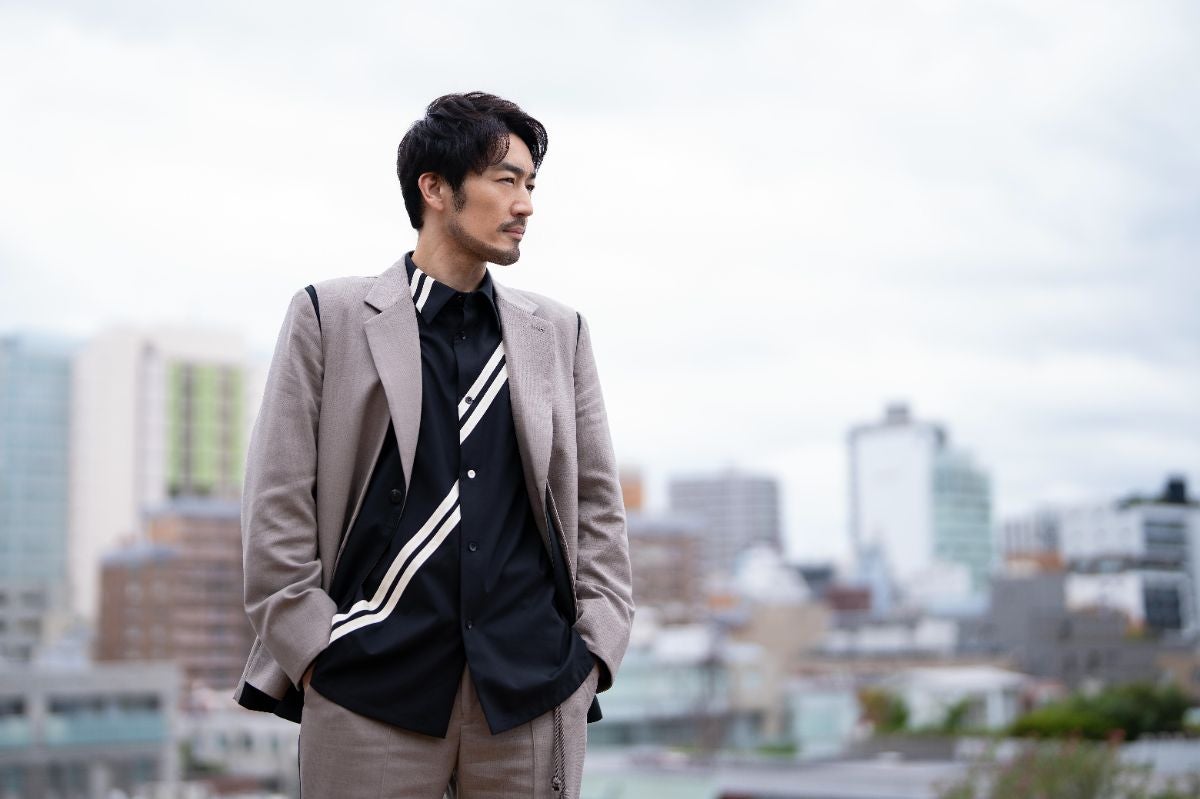 街の景色を背景に凛と佇む大谷亮平さん
