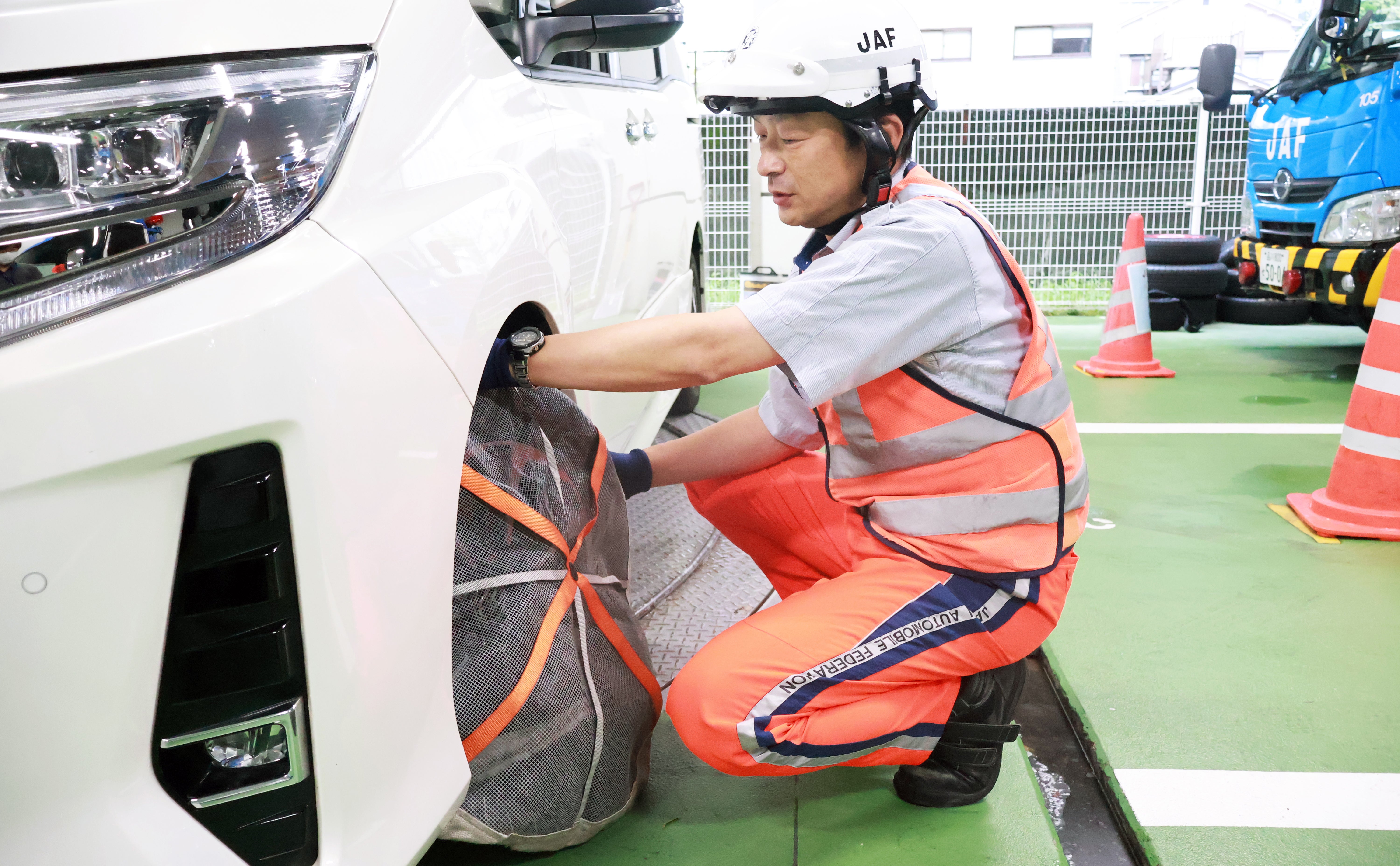 雪道での救援作業で使用する布製タイヤチェーンを装着する原田隊員