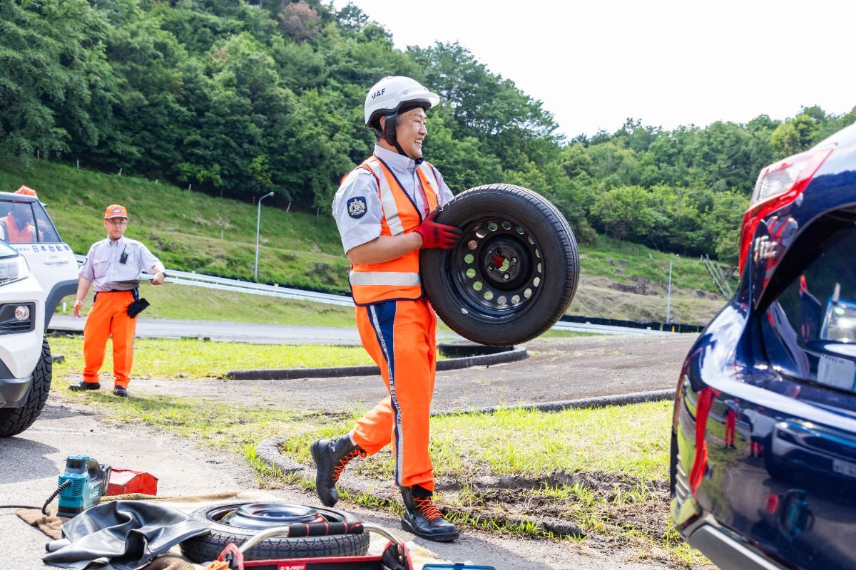 パンク修理の競技でタイヤを運ぶ藤沢選手