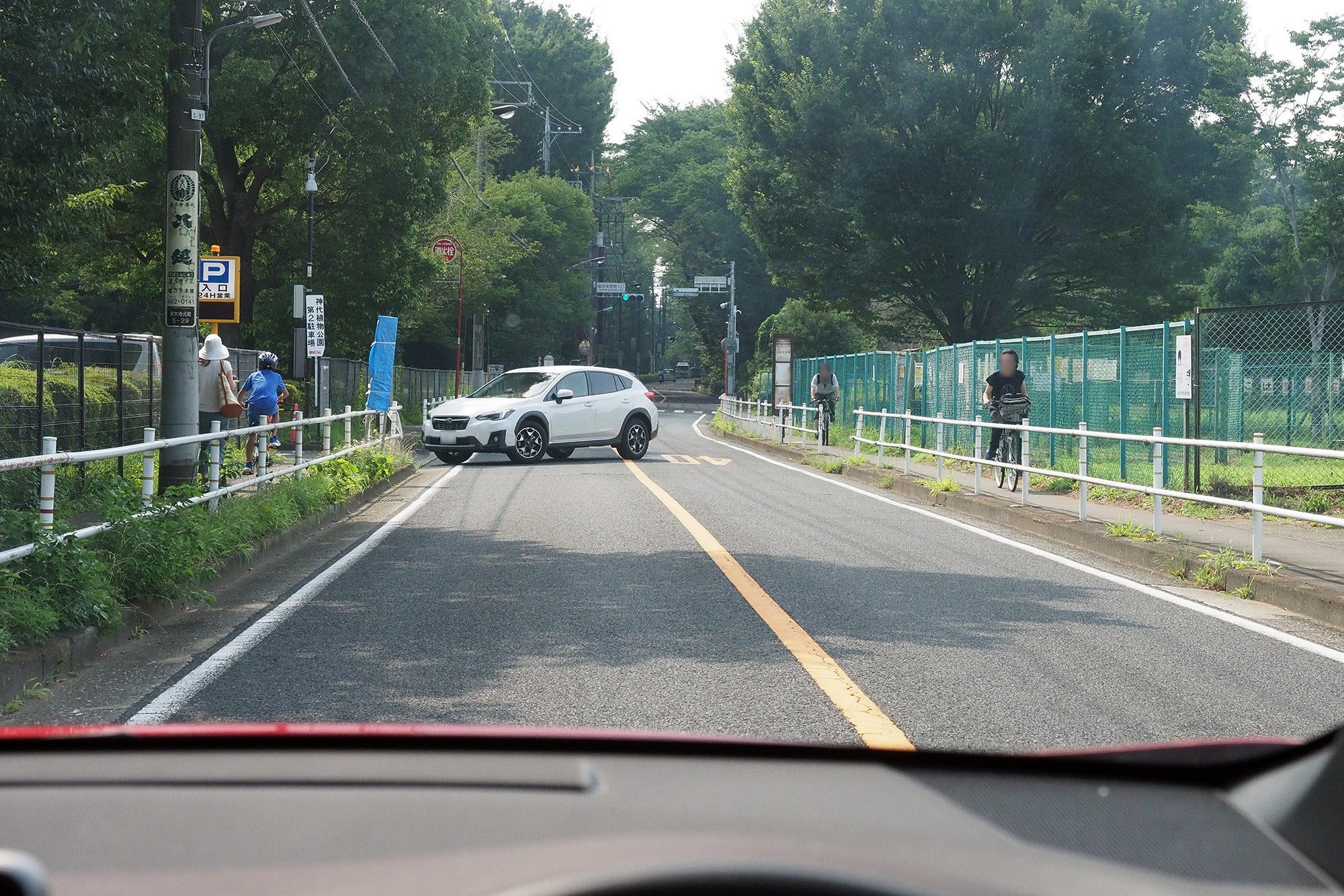 歩道を横切って駐車場に入ろうとする対向車