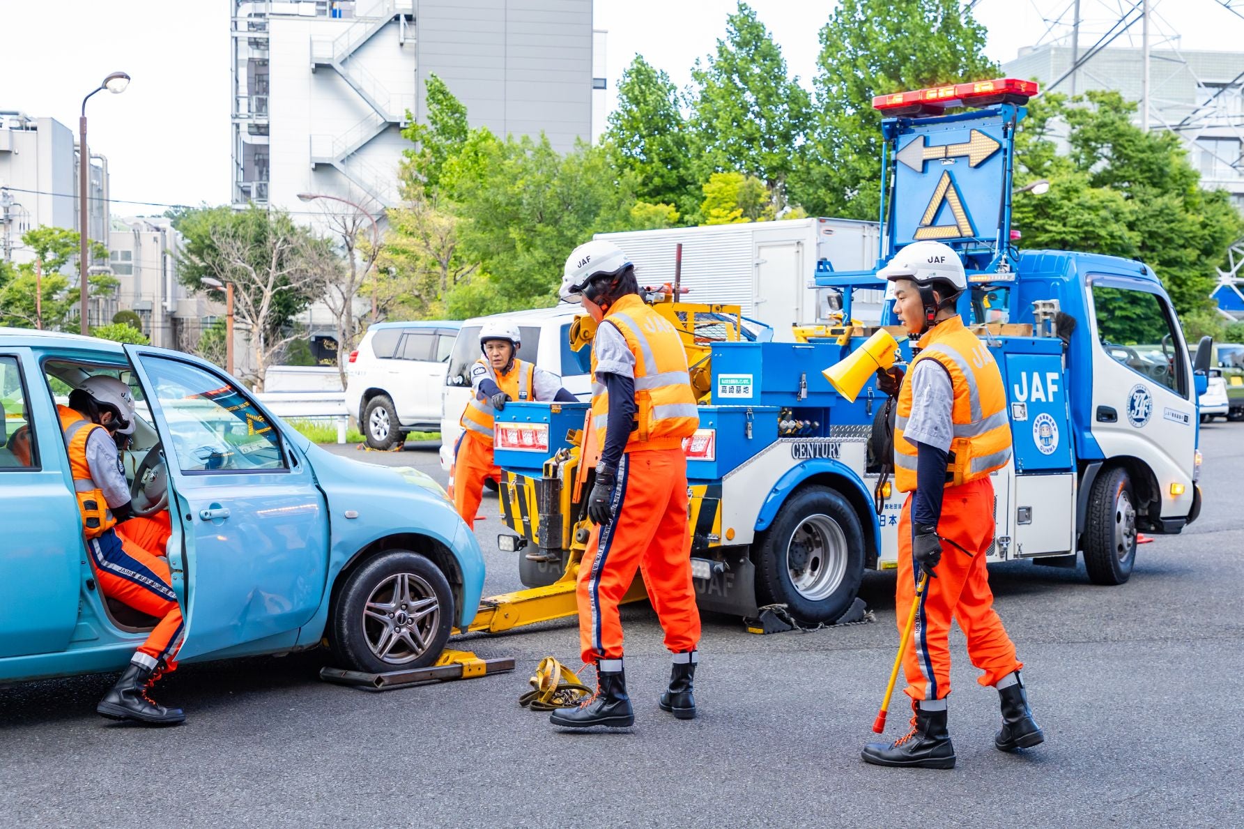 起した車体をレッカー移動する準備をおこなう選手たち